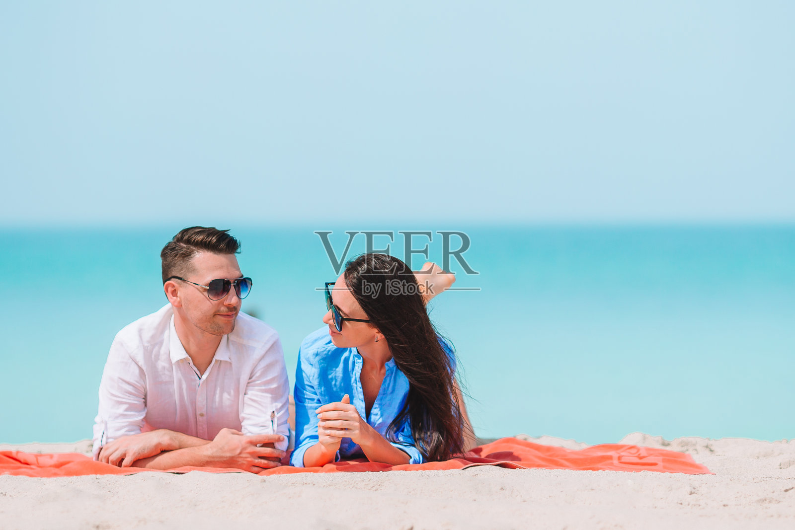 在白色海滩上度假的年轻情侣照片摄影图片