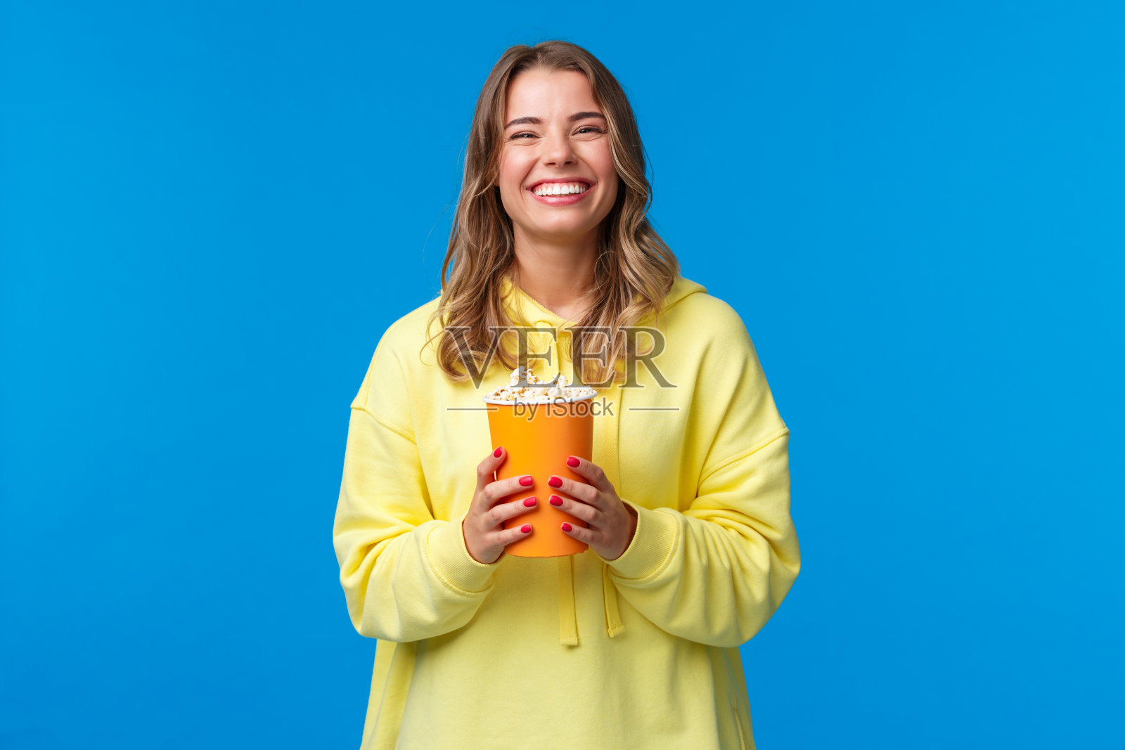 金发欧洲女人电影院看电影吃爆米花照片摄影图片