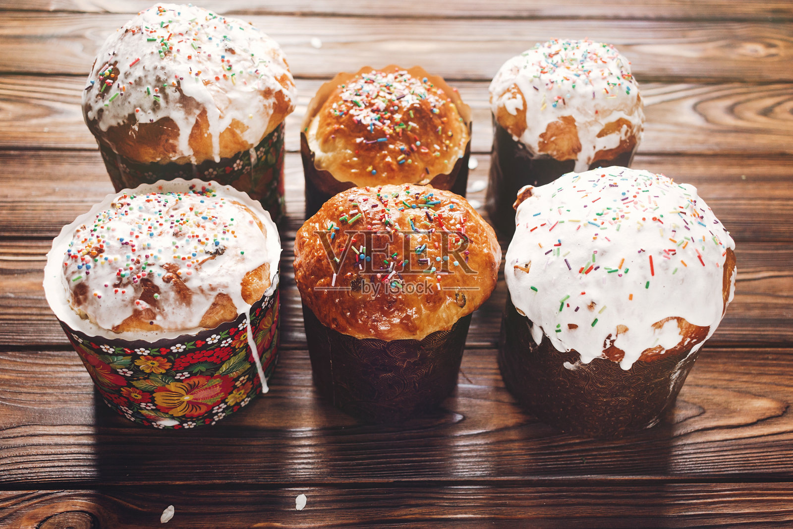 美味的复活节面包蛋糕与彩色的糖霜顶视图在木制的背景。为传统的复活节盛宴自制面包照片摄影图片