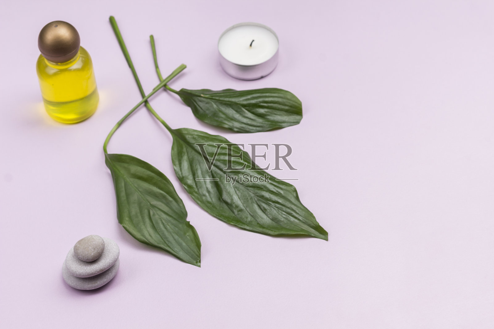 绿叶,蜡烛。石头平衡金字塔。水疗中心放松的概念。粉红色的背景。副本的空间。顶视图“n照片摄影图片