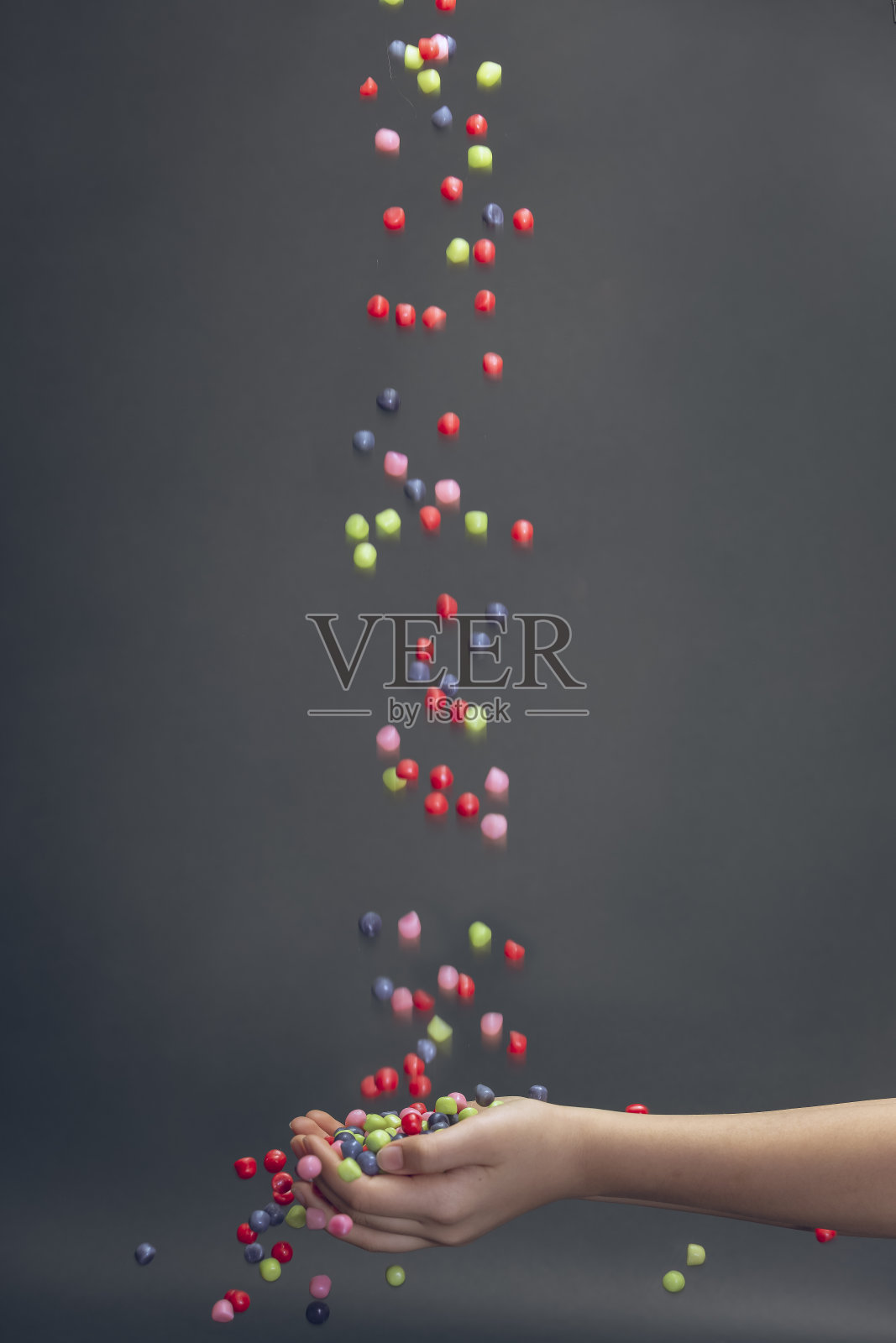 五彩缤纷的糖果落在两个孩子的手里照片摄影图片