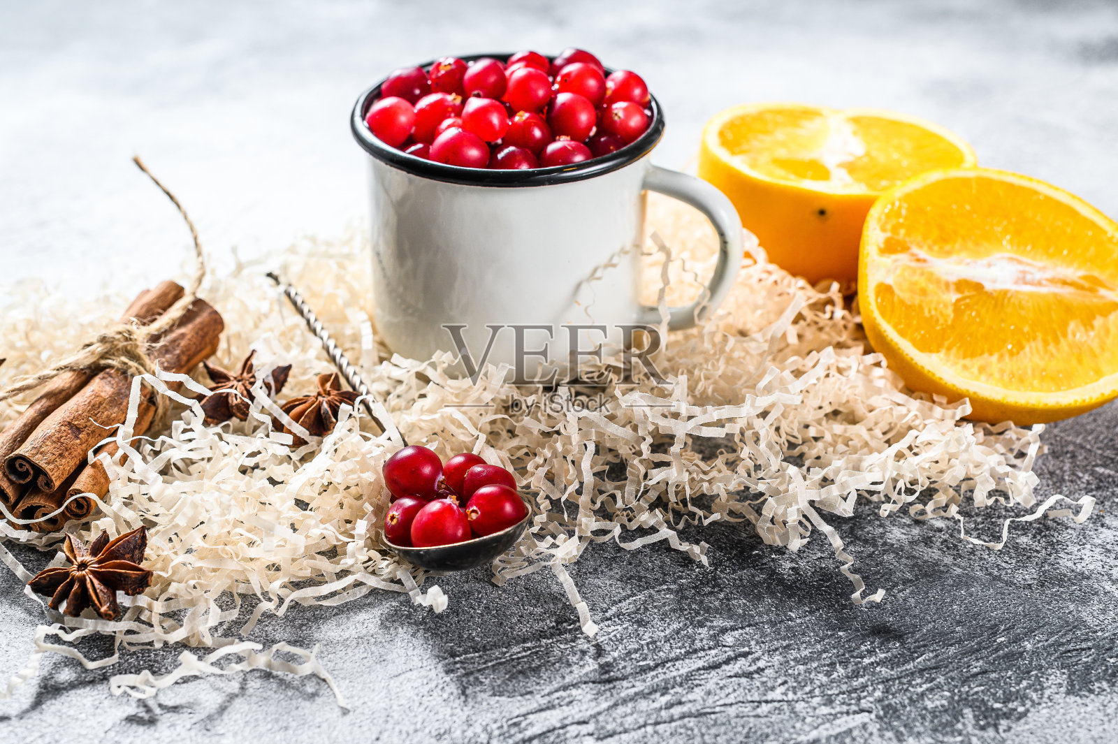 加香料的热葡萄酒配方。配料有蔓越莓，橘子，肉桂，茴香和小豆蔻。灰色的背景。俯视图照片摄影图片