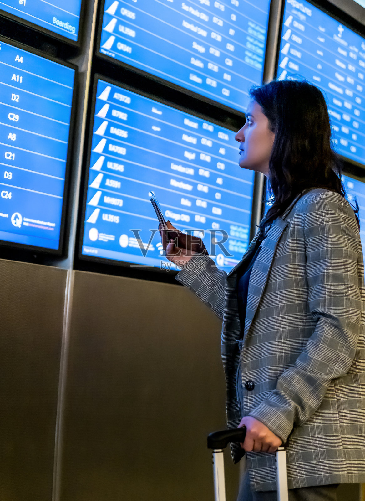 年轻女子在国际机场查看航班信息照片摄影图片