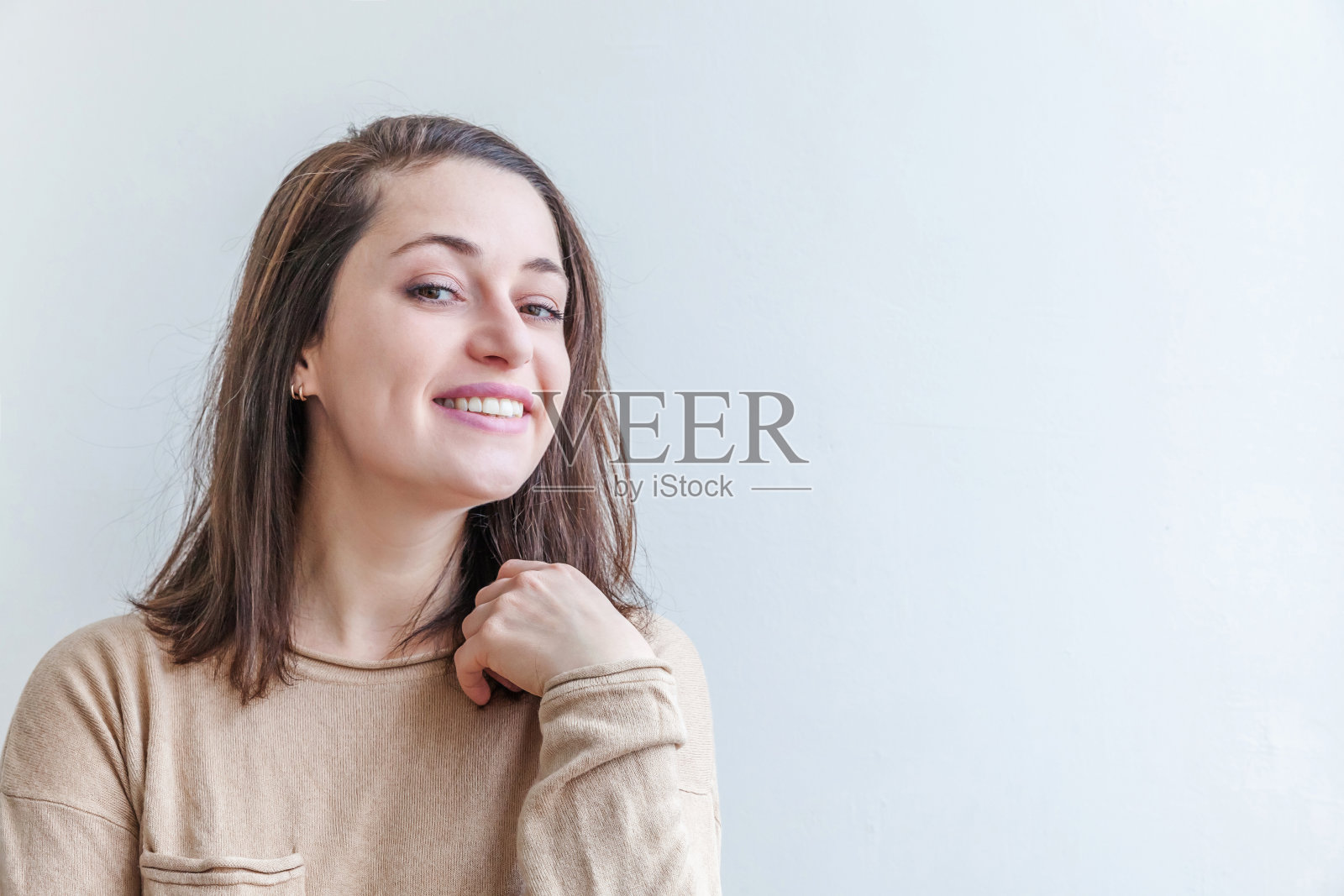 快乐的女孩微笑著，在白色背景下，年轻快乐的积极的棕发女子面部表情照片摄影图片