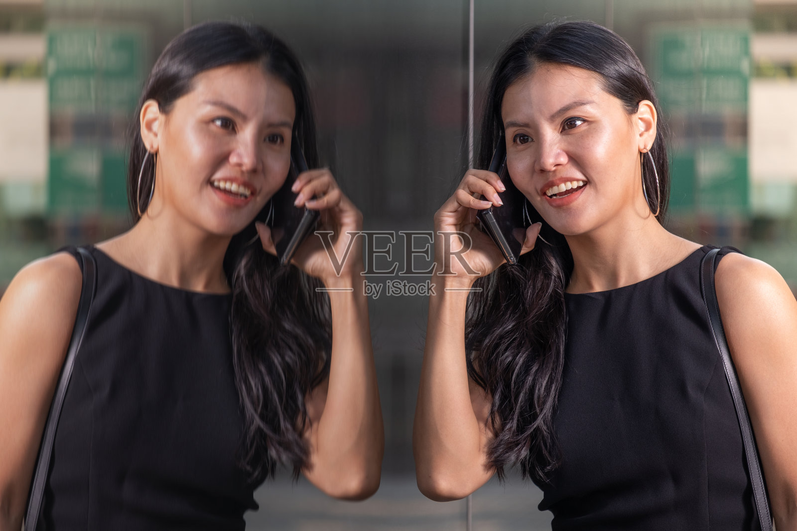 在建筑物前使用手机的亚洲女性照片摄影图片