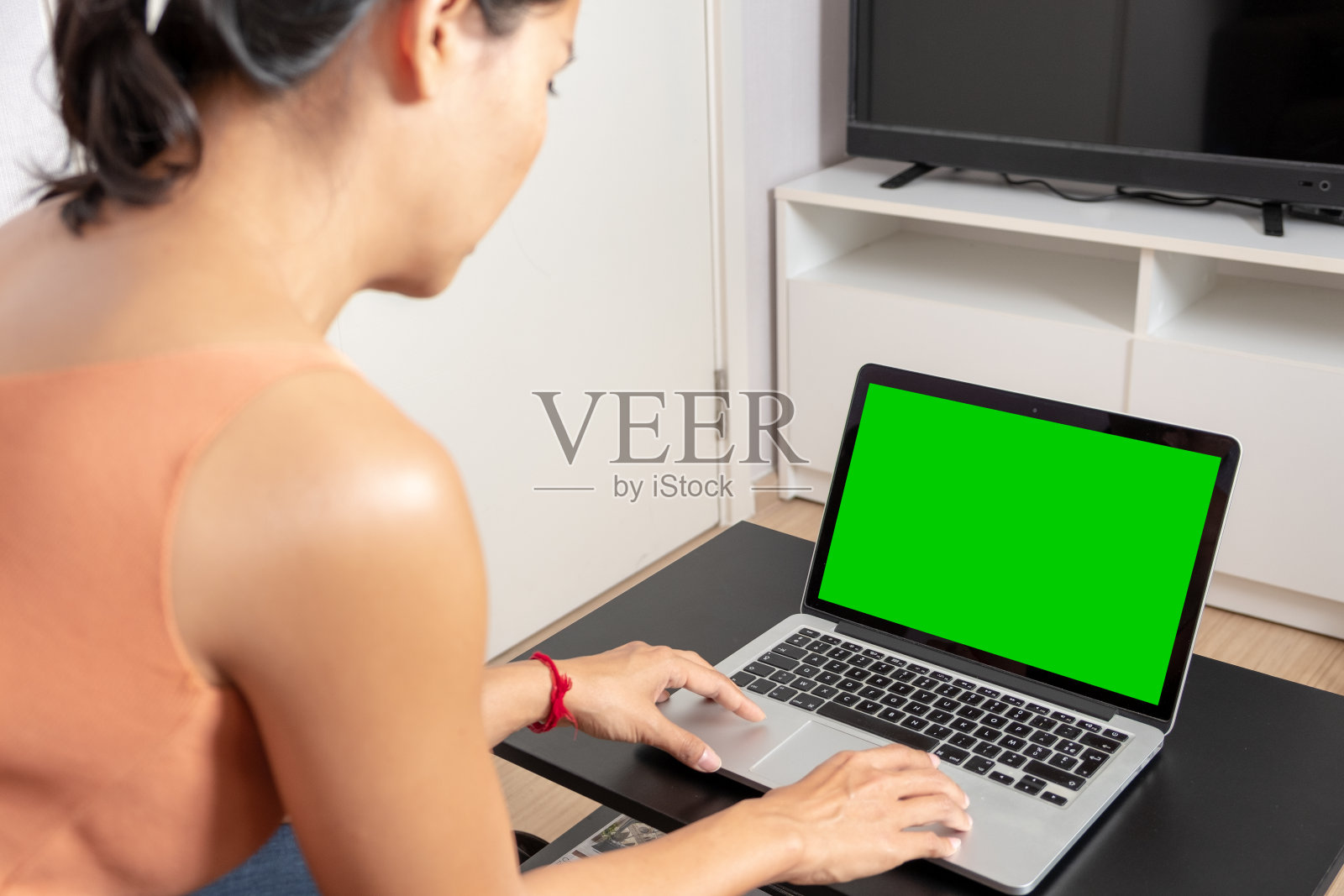 女人在看笔记本电脑上的绿色屏幕照片摄影图片