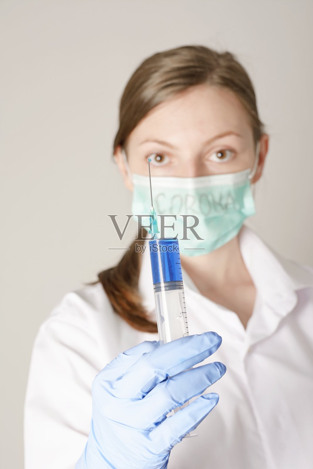 冠状病毒疫苗。女医生（模糊）拿着注射器。照片摄影图片