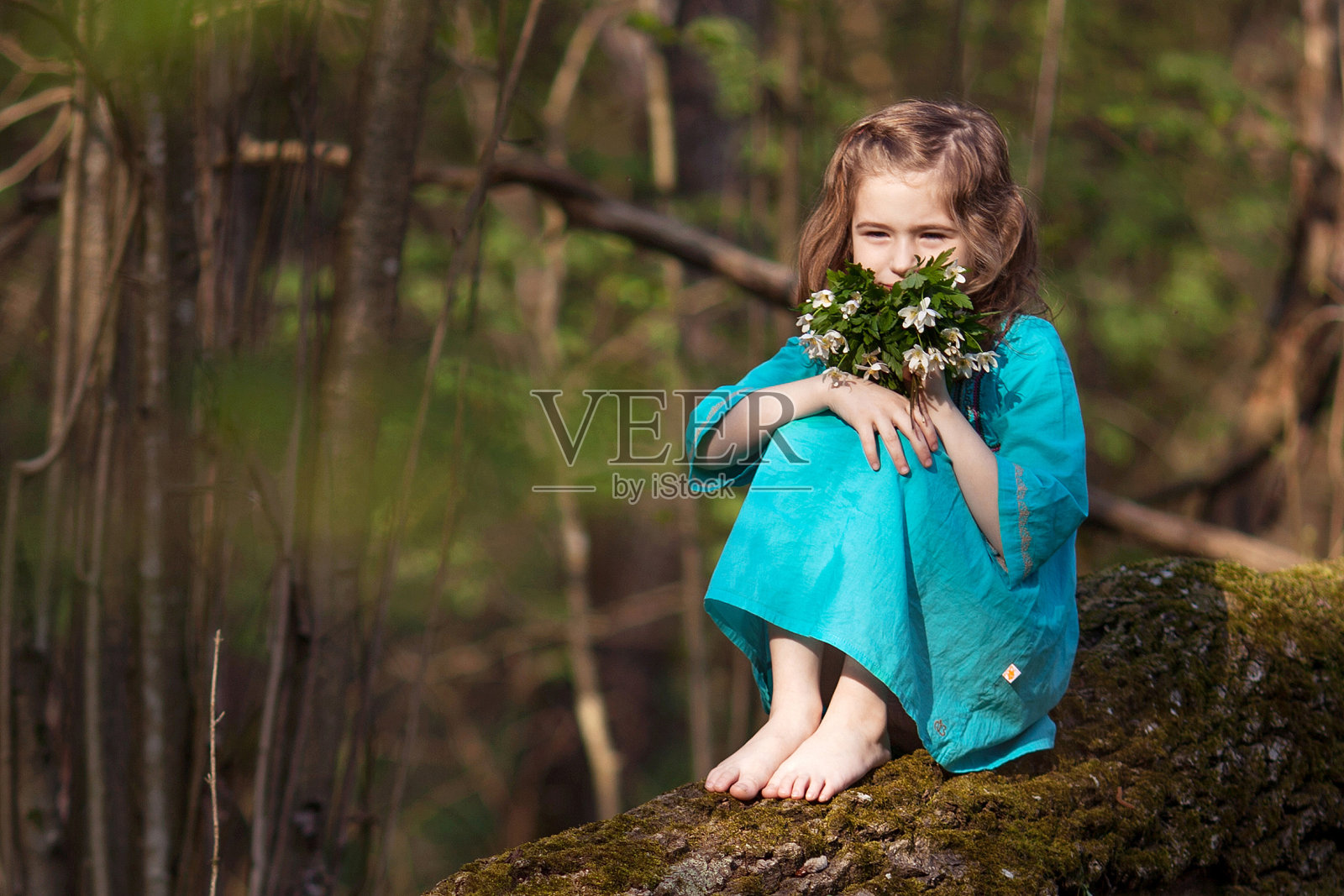 在春季树林中散步的蓝裙可爱小女孩照片摄影图片