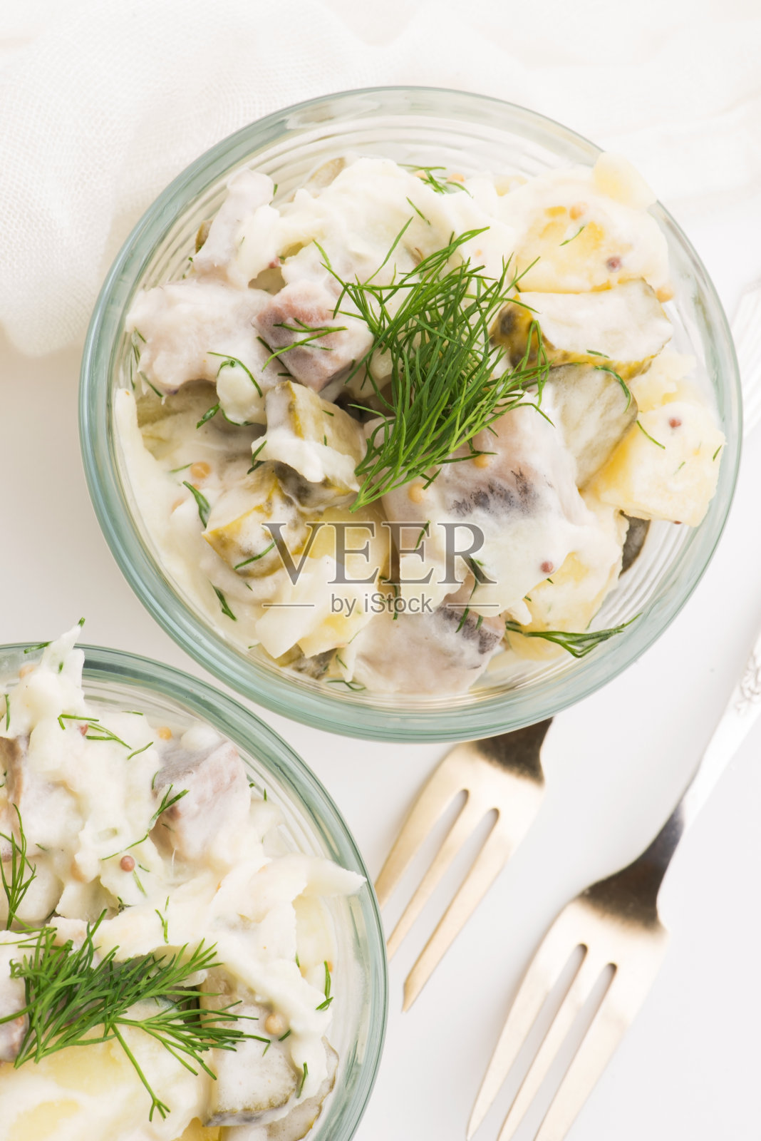 用鲱鱼、黄瓜和土豆做成的沙拉酱，淋上蛋黄酱和芥末照片摄影图片