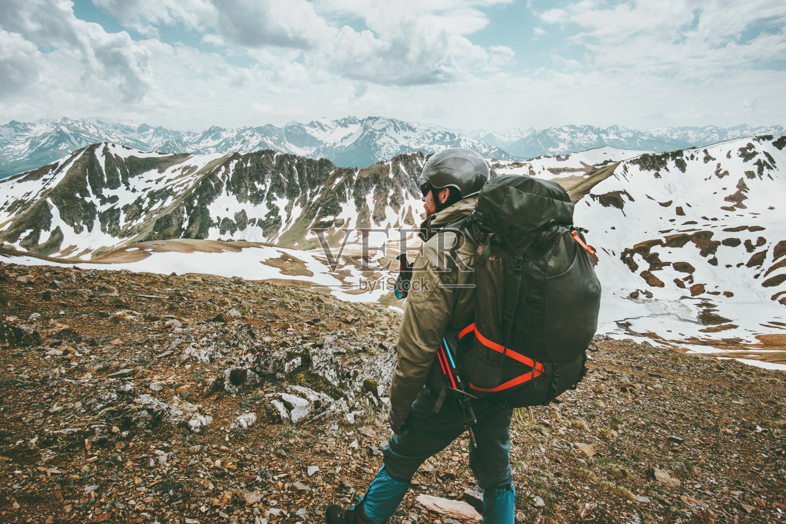 男子背着大背包在山区徒步旅行，体验户外探险照片摄影图片