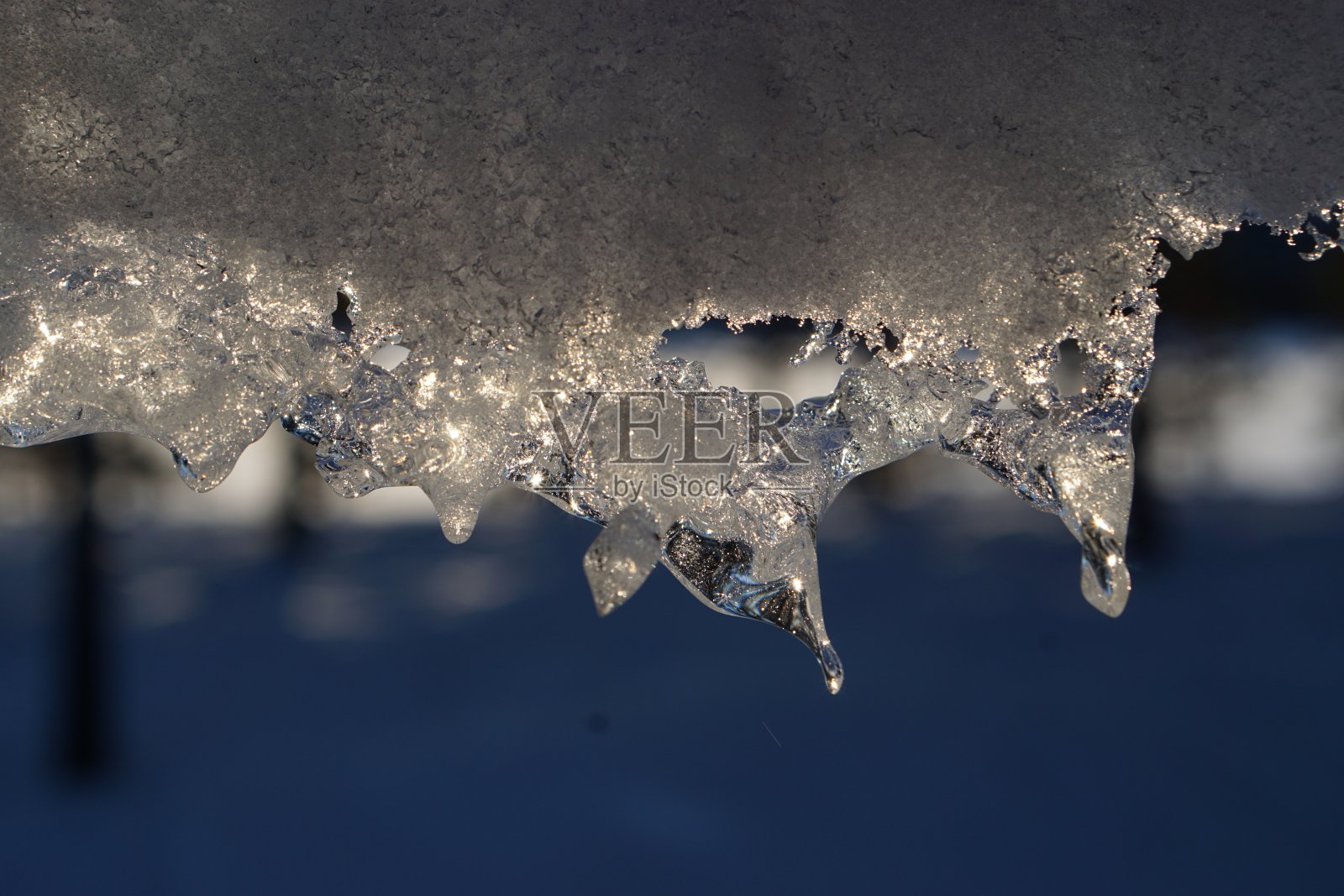 冰雪从屋顶上滑下来。照片摄影图片