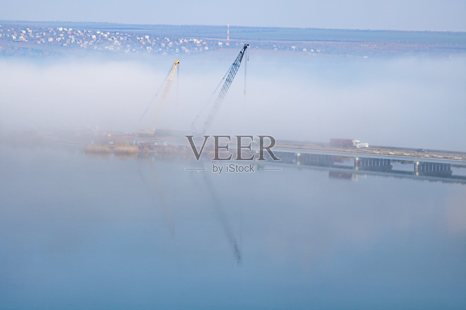 在雾中的吊车和桥上的汽车照片摄影图片