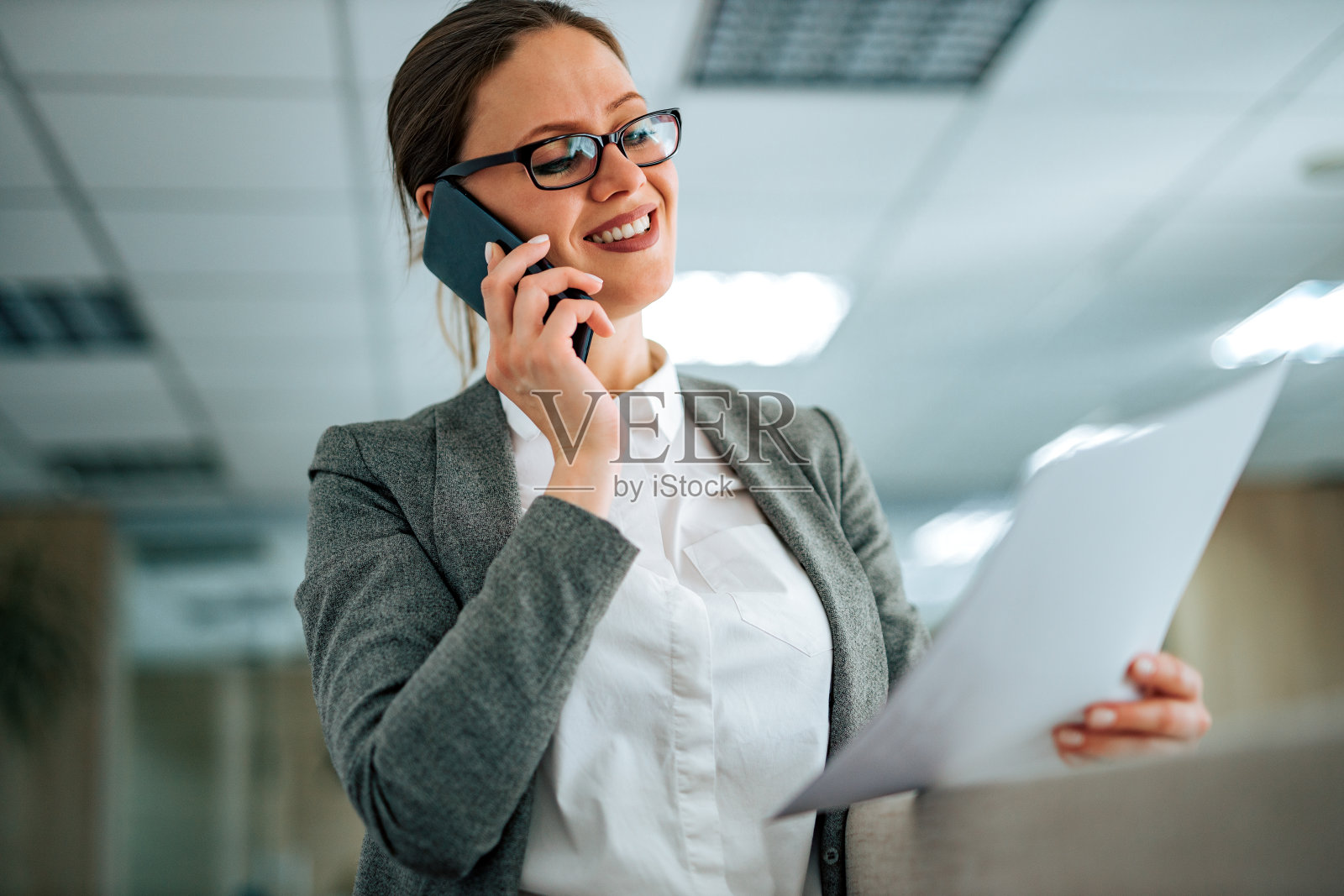 打电话并拿着文件的女商人特写照片摄影图片