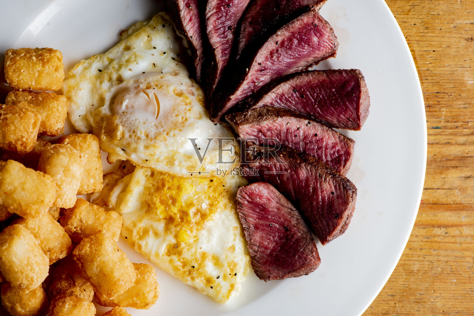 牛排和鸡蛋。传统的经典美国餐厅或法国小酒馆早午餐项目，牛排和鸡蛋与孩子。安格斯牛排配半熟煎蛋和香脆家常薯条。照片摄影图片