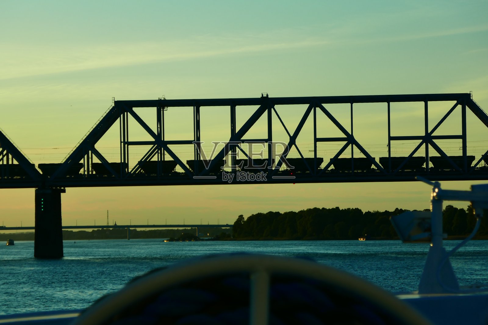 伏尔加河上的一艘船在铁桥上拍摄的日落照片摄影图片