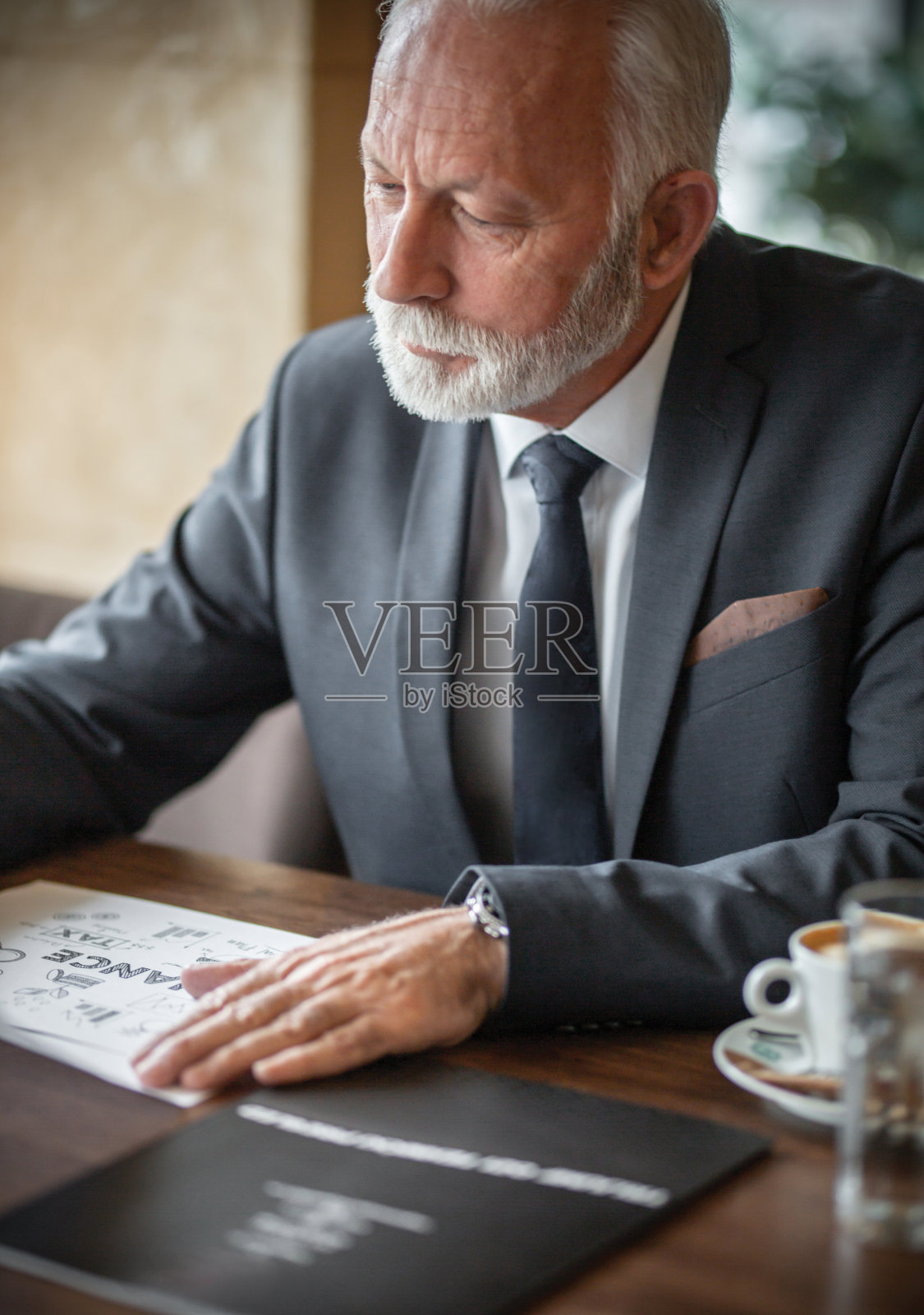 在餐厅查看项目的老商人（库存照片）照片摄影图片