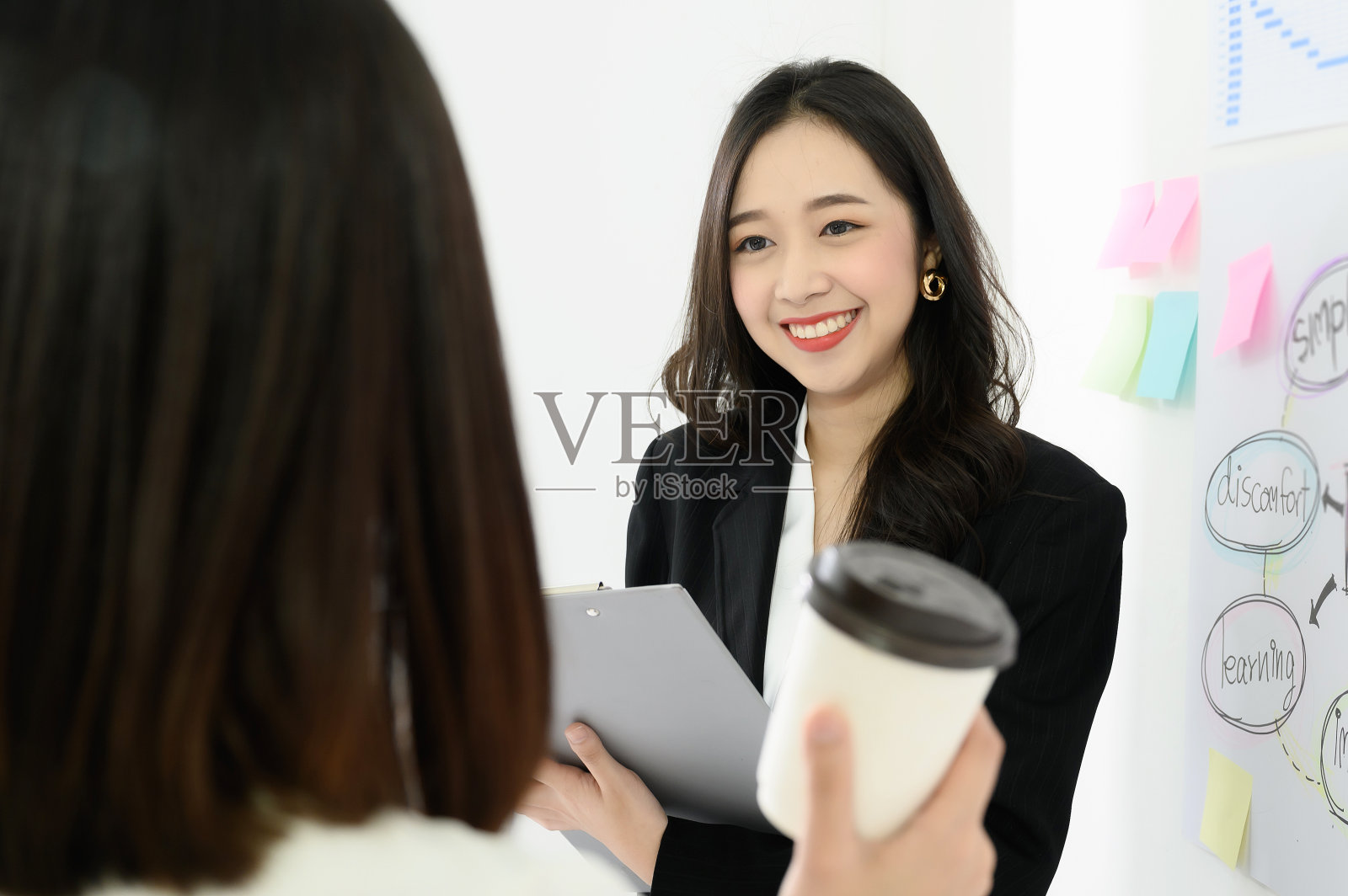 两个美丽的年轻亚洲商业女人有乐趣和谈论或在工作场所讨论工作照片摄影图片