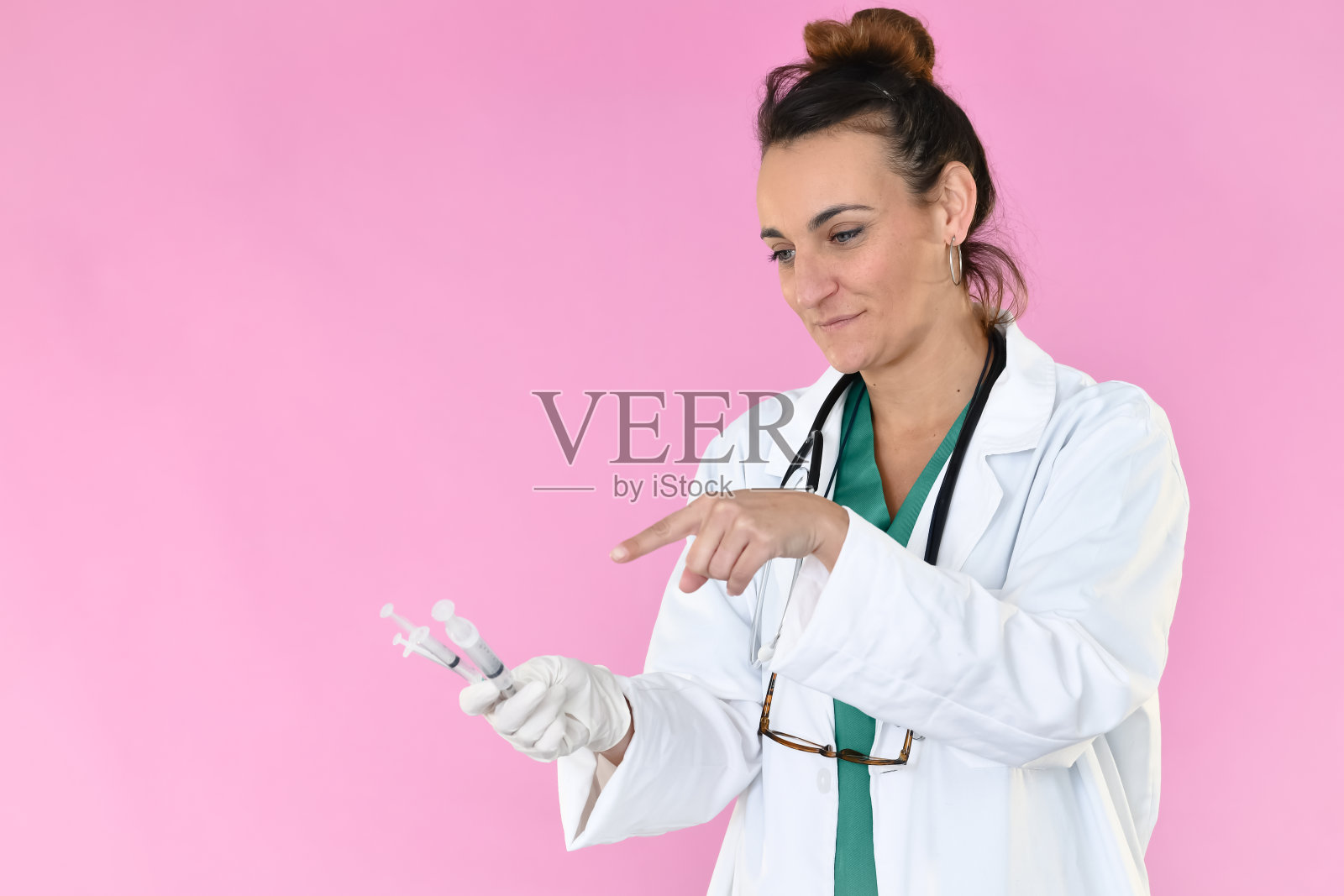 微笑的女医生正在指点注射器照片摄影图片