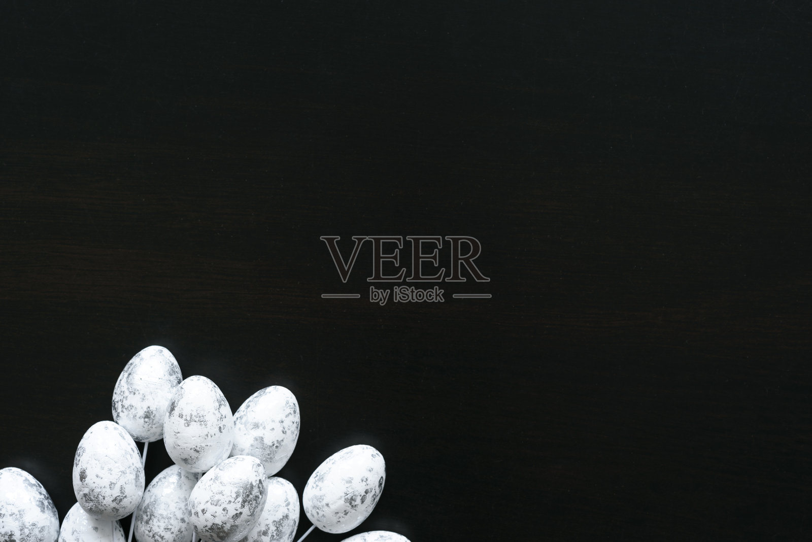复活节安排与拷贝空间在黑色背景。带有银色细部的白色鸡蛋。照片摄影图片