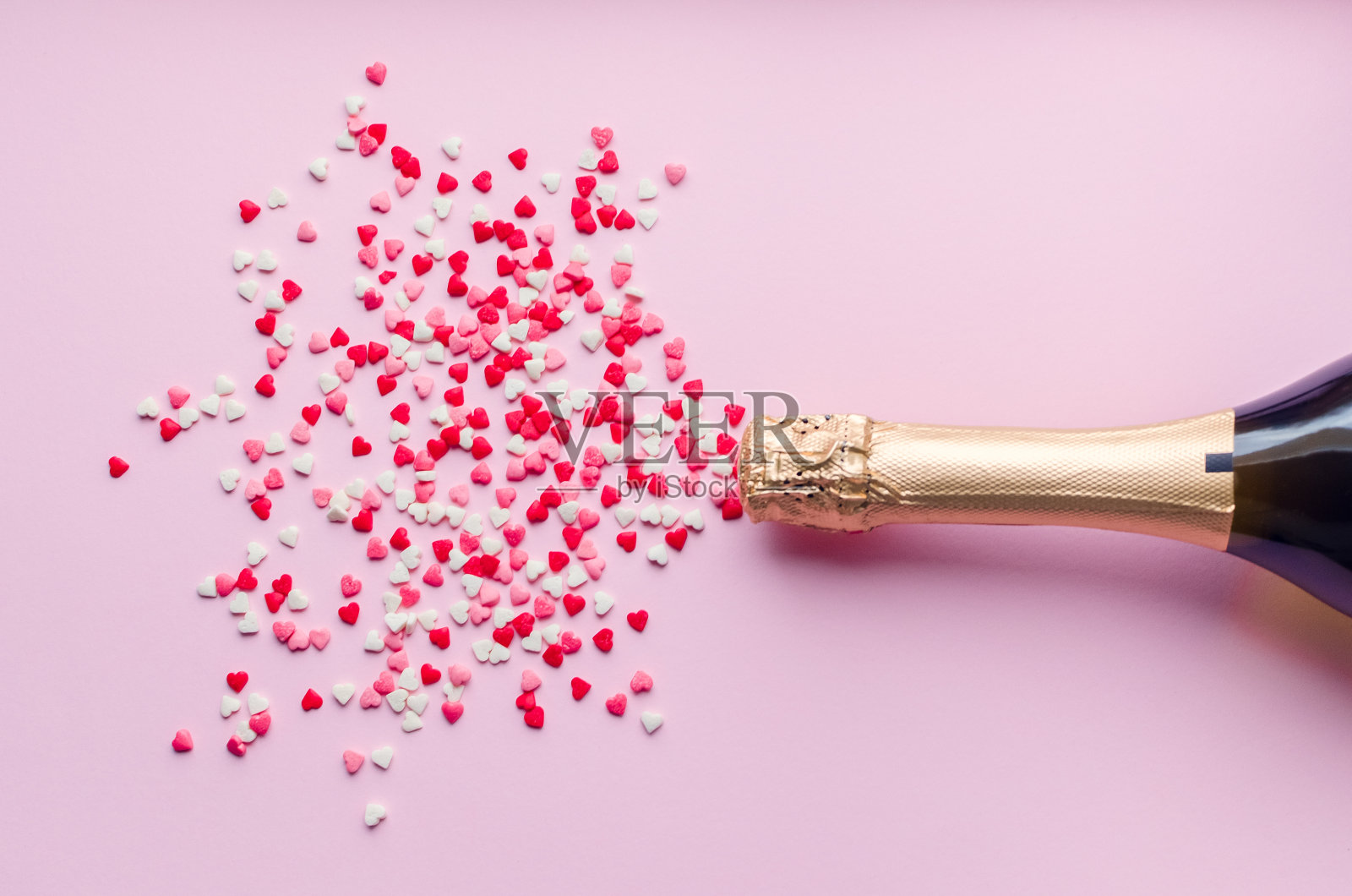 粉红背景的香槟瓶照片摄影图片