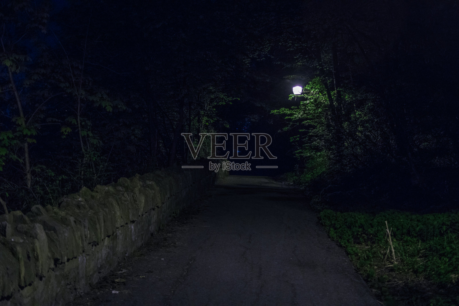 在人行道上的岩石墙照片摄影图片