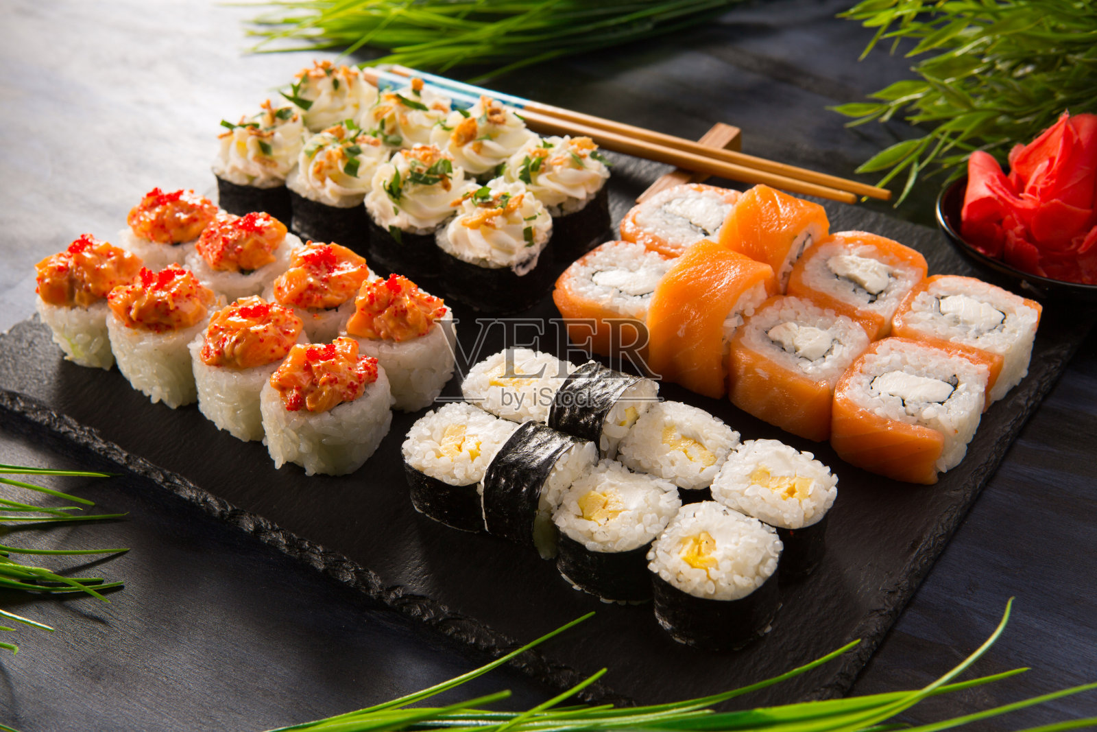 一套寿司卷与芥末和生姜在黑色的背景。日本东方美食照片摄影图片