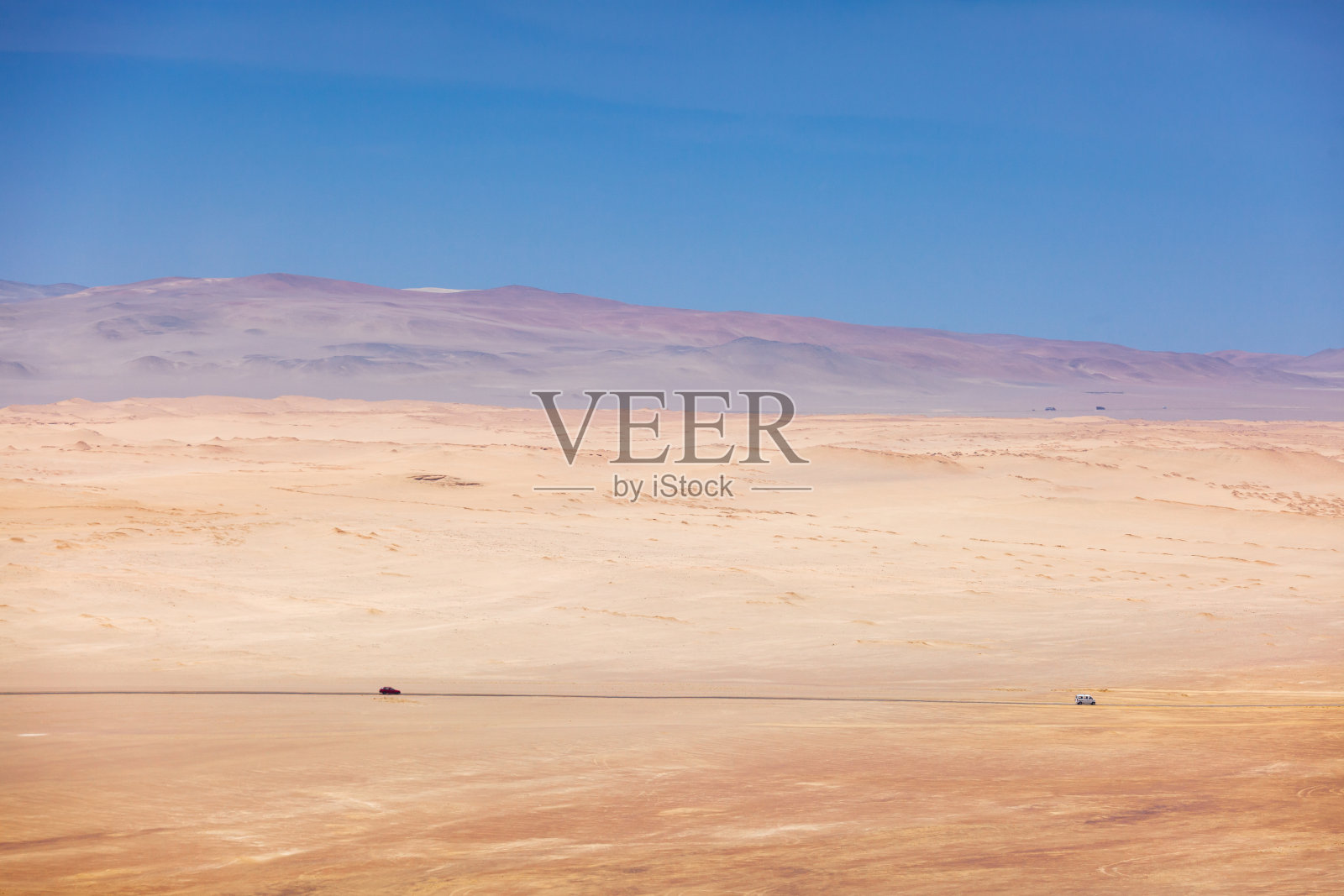 看沙漠，在远处两辆车走在帕拉卡斯国家保护区的路上。照片摄影图片