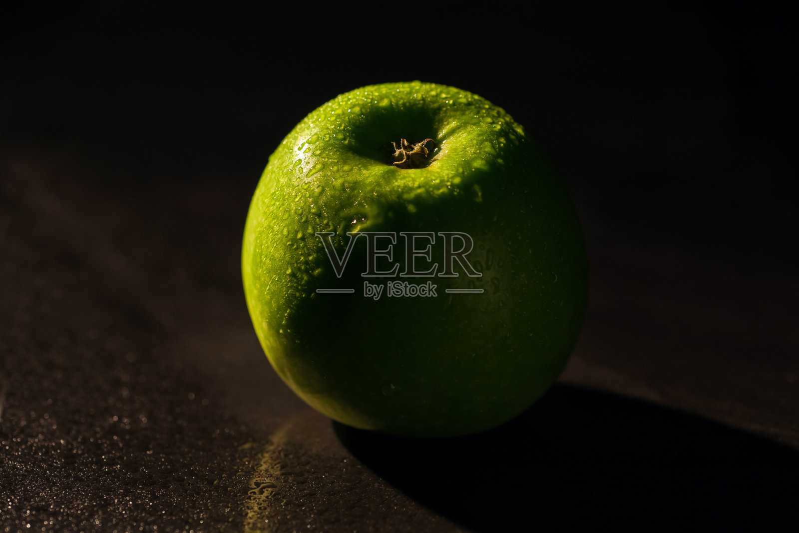 黑背景上的青苹果。照片摄影图片