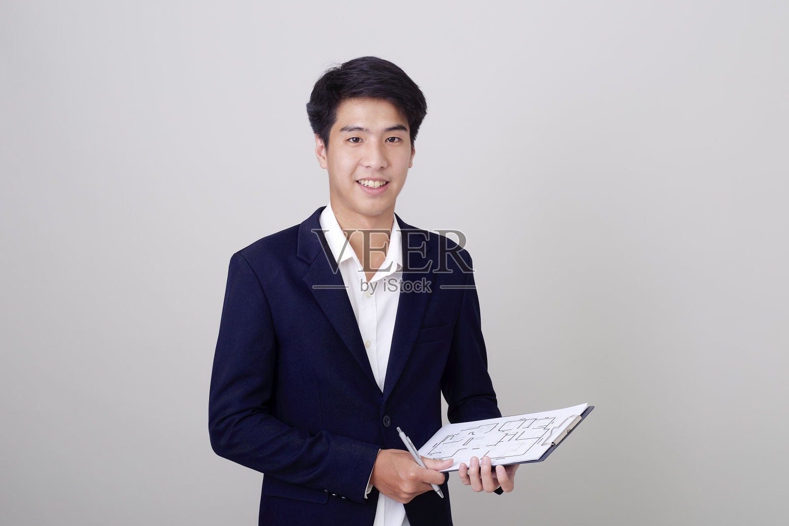 有吸引力的男人在时尚的西装拿着剪贴板上的白色背景上的白色背景照片摄影图片