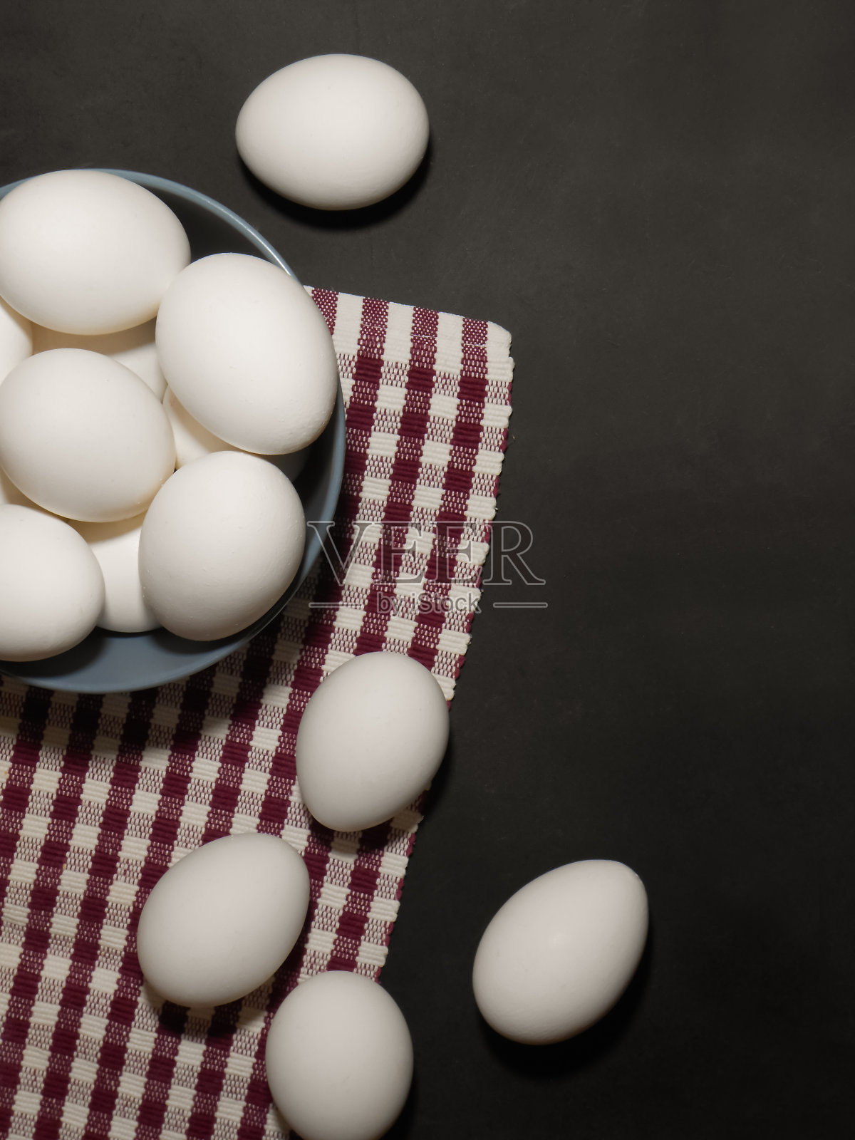 烹饪配料鸡蛋和厨房纺织品在黑色的背景。副本的空间。照片摄影图片