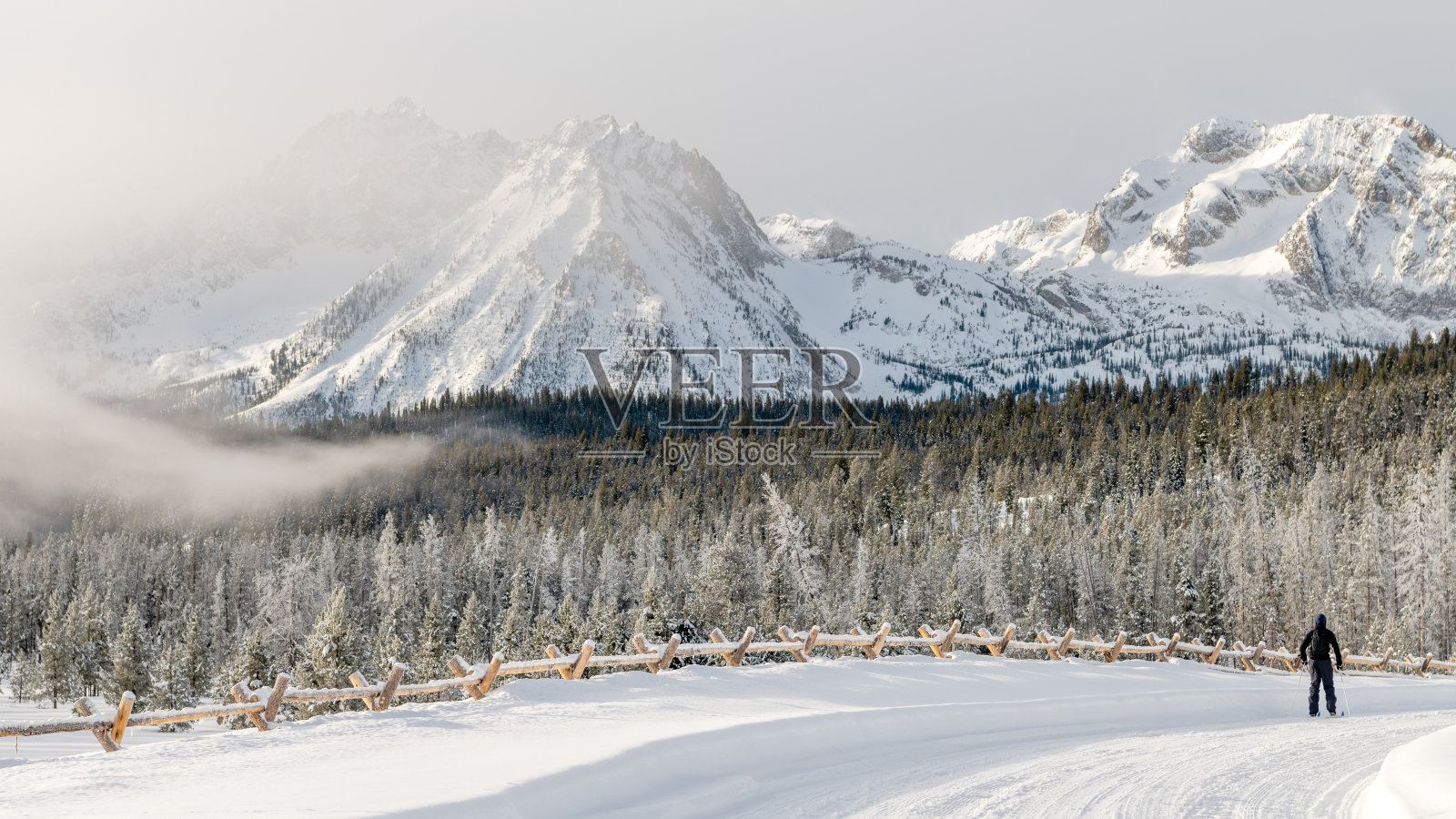 孤独的越野滑雪者沿着一条小径上山照片摄影图片
