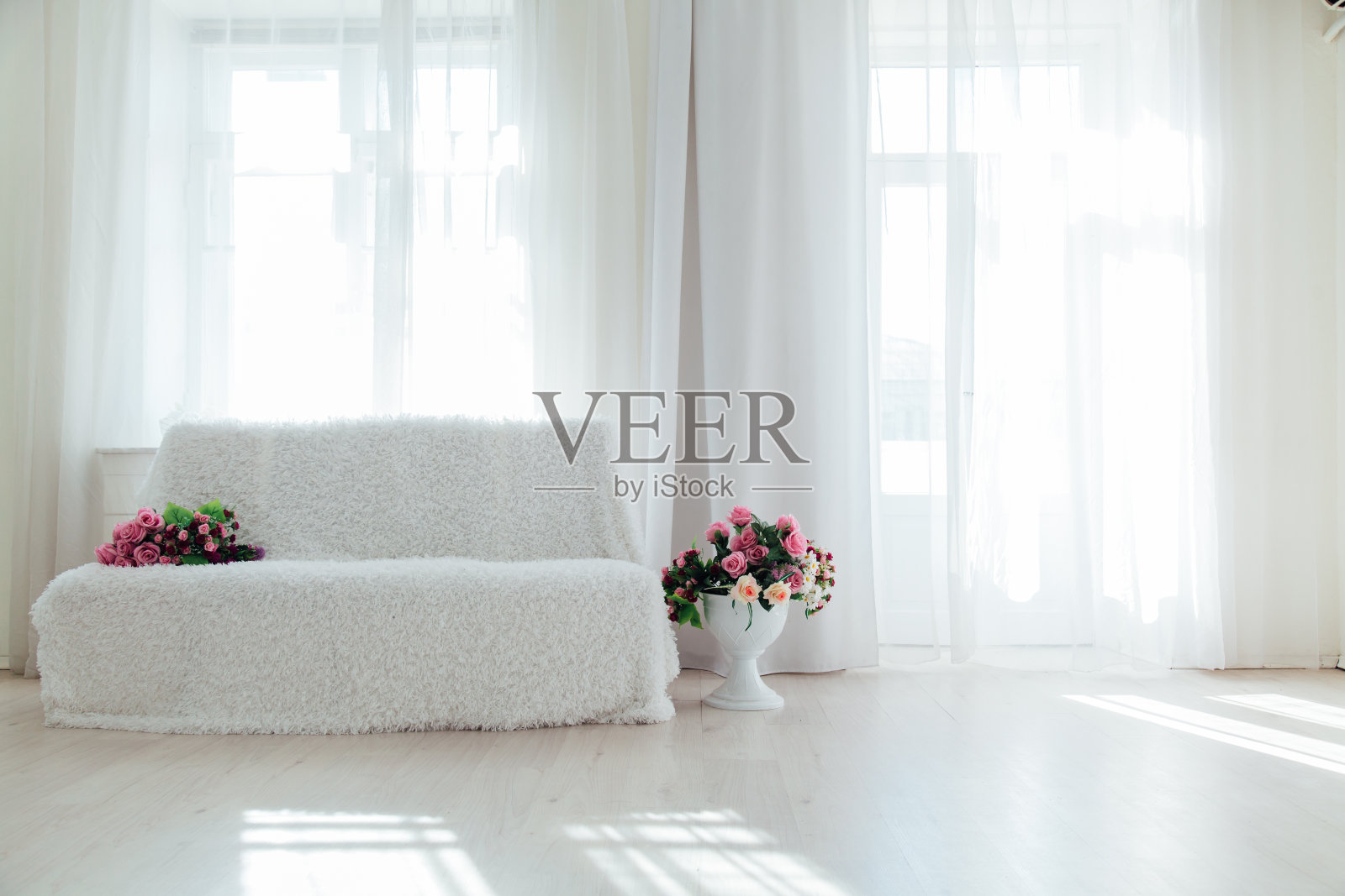 白色的房间里孤零零地摆着带花的白色沙发照片摄影图片