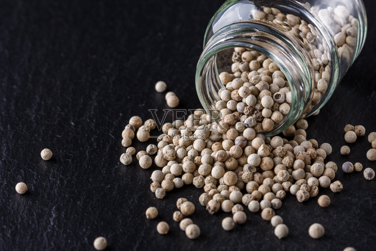 白色的花椒在深色的石板石背景上照片摄影图片