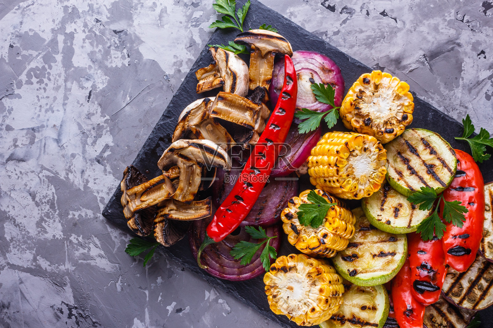 美味新鲜的烤蔬菜放在石盘上照片摄影图片