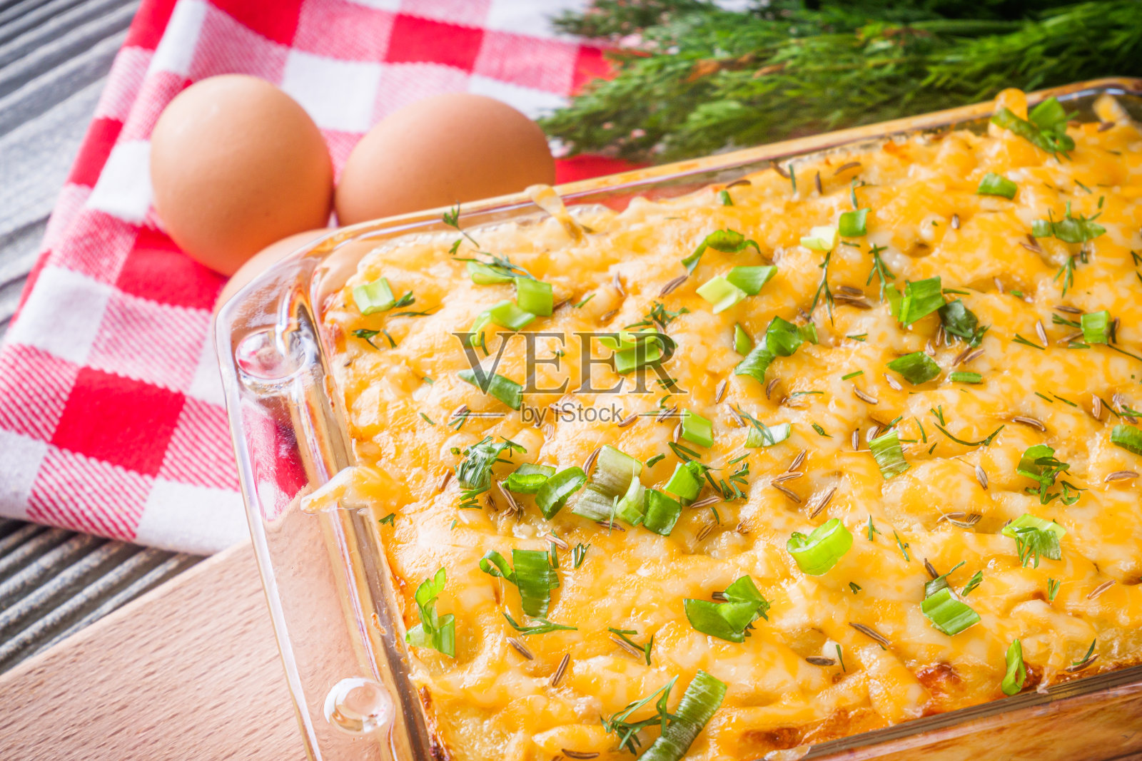 美味的土豆砂锅，鸡蛋和奶酪在灰色的木制背景照片摄影图片