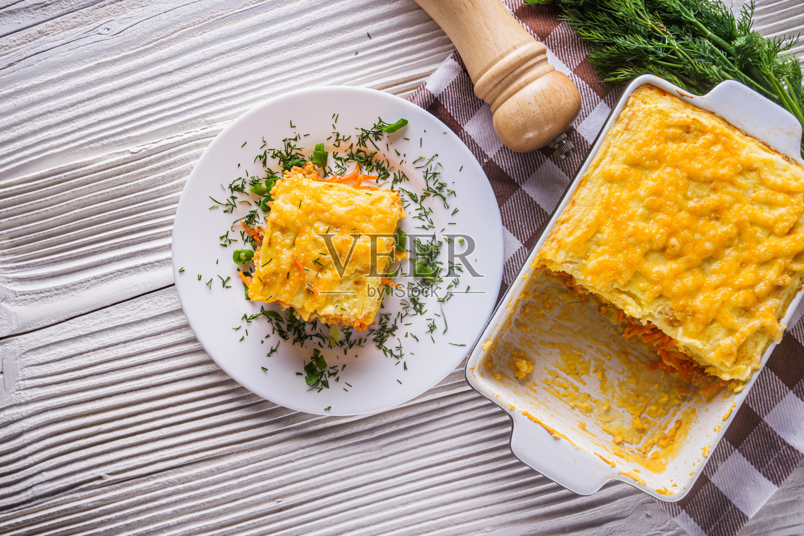 美味的土豆砂锅，肉和奶酪在白色的木制背景照片摄影图片