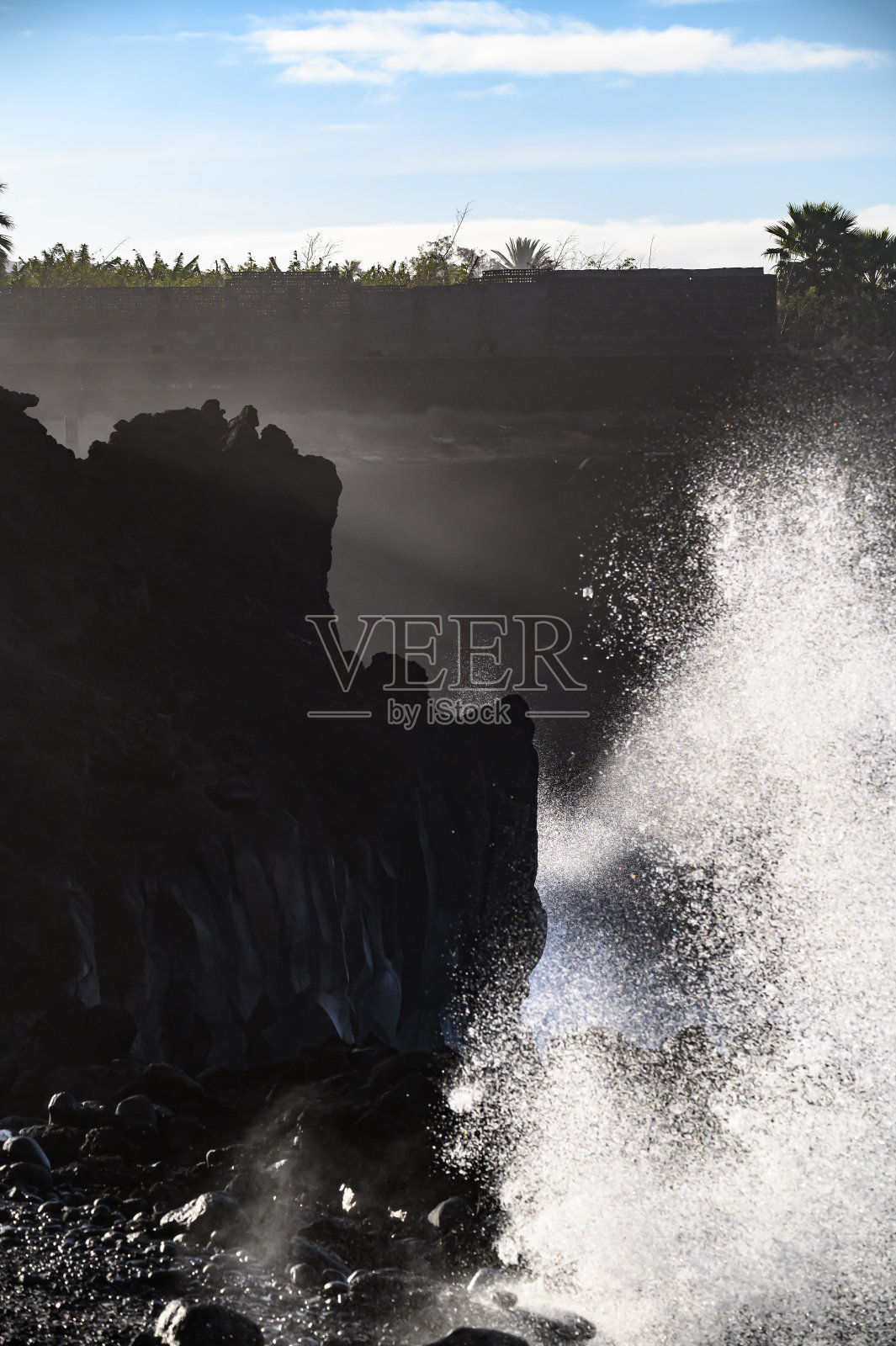 在西班牙加那利的拉帕尔马岛，危险的海洋风暴海浪袭击黑色的熔岩岩石照片摄影图片