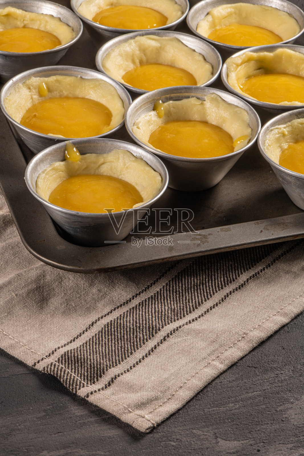 烘烤前的传统葡萄牙甜点蛋挞。奶油蛋挞面团照片摄影图片