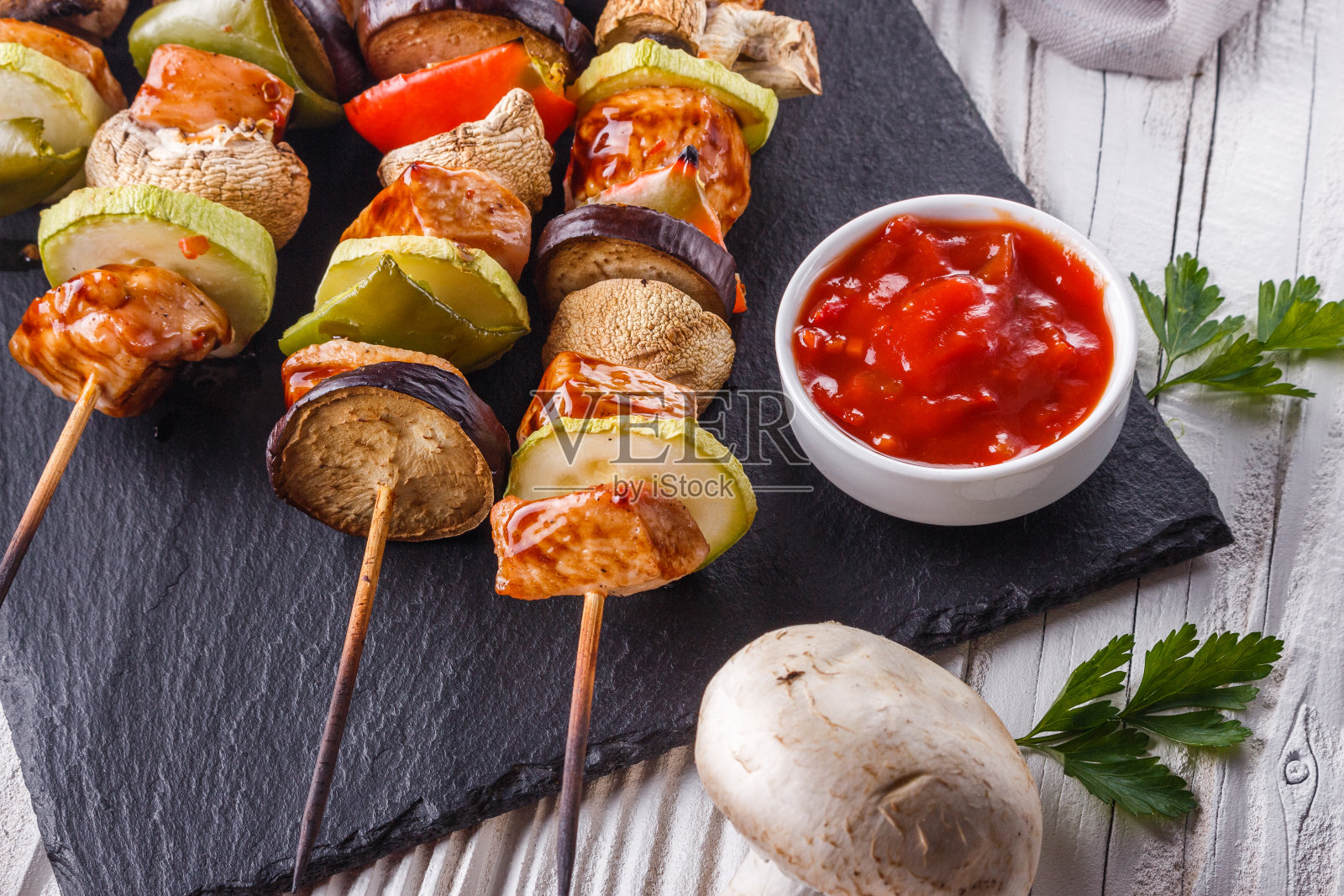 田园背景下的鸡肉串、蔬菜和蘑菇照片摄影图片
