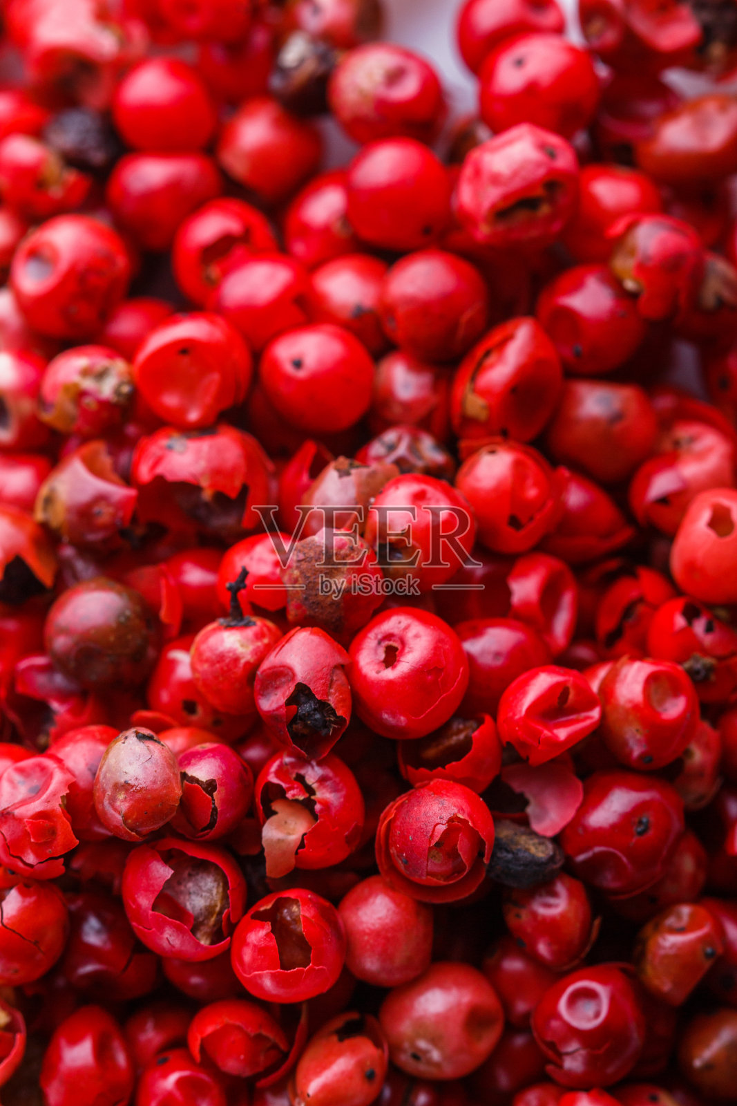 白色的丙烯酸背景上点缀着芬芳的粉色花椒照片摄影图片