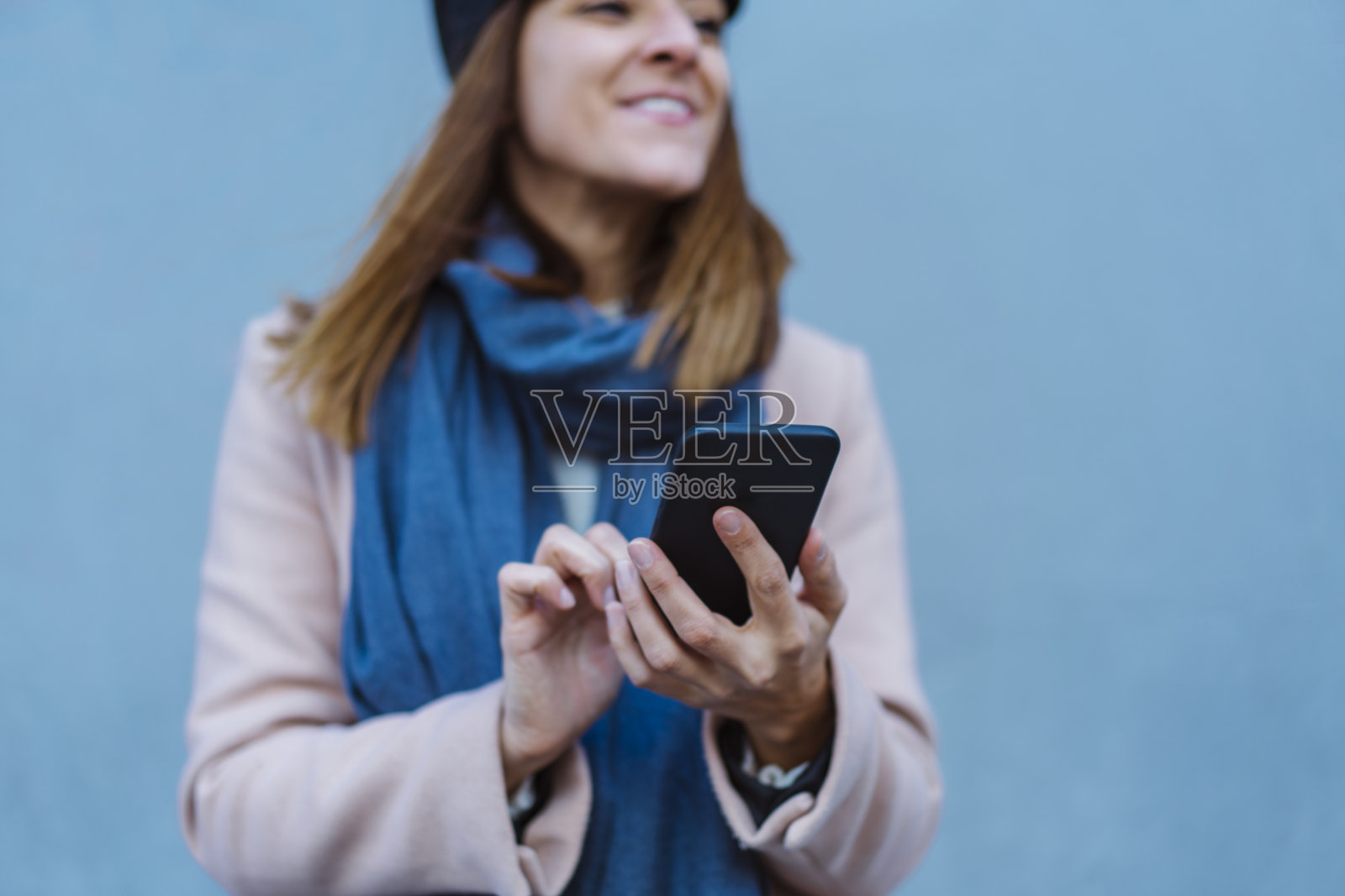 在蓝色背景中发短信的年轻女子照片摄影图片