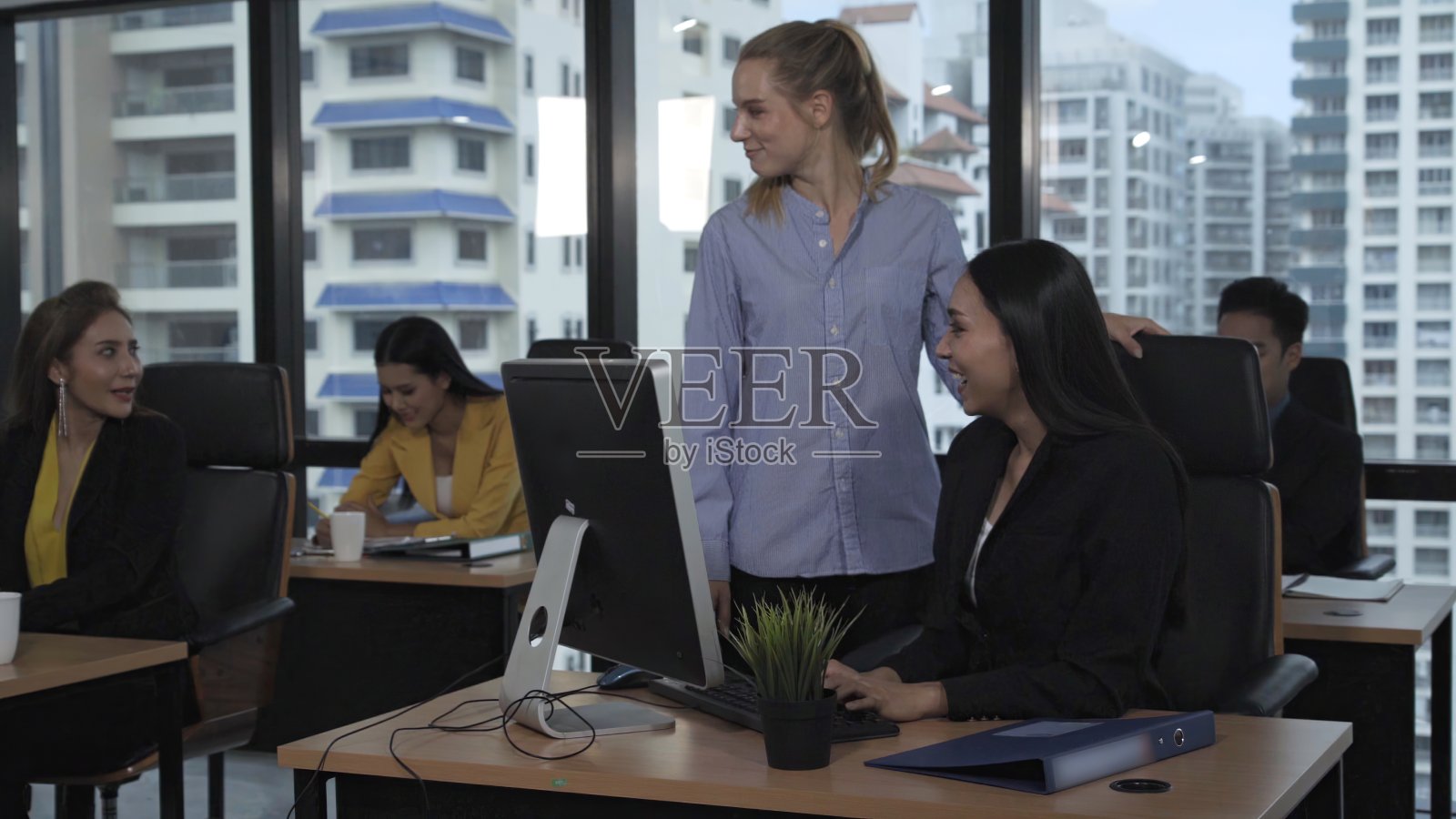 年轻的领导者向年轻的女工人提供建议。照片摄影图片