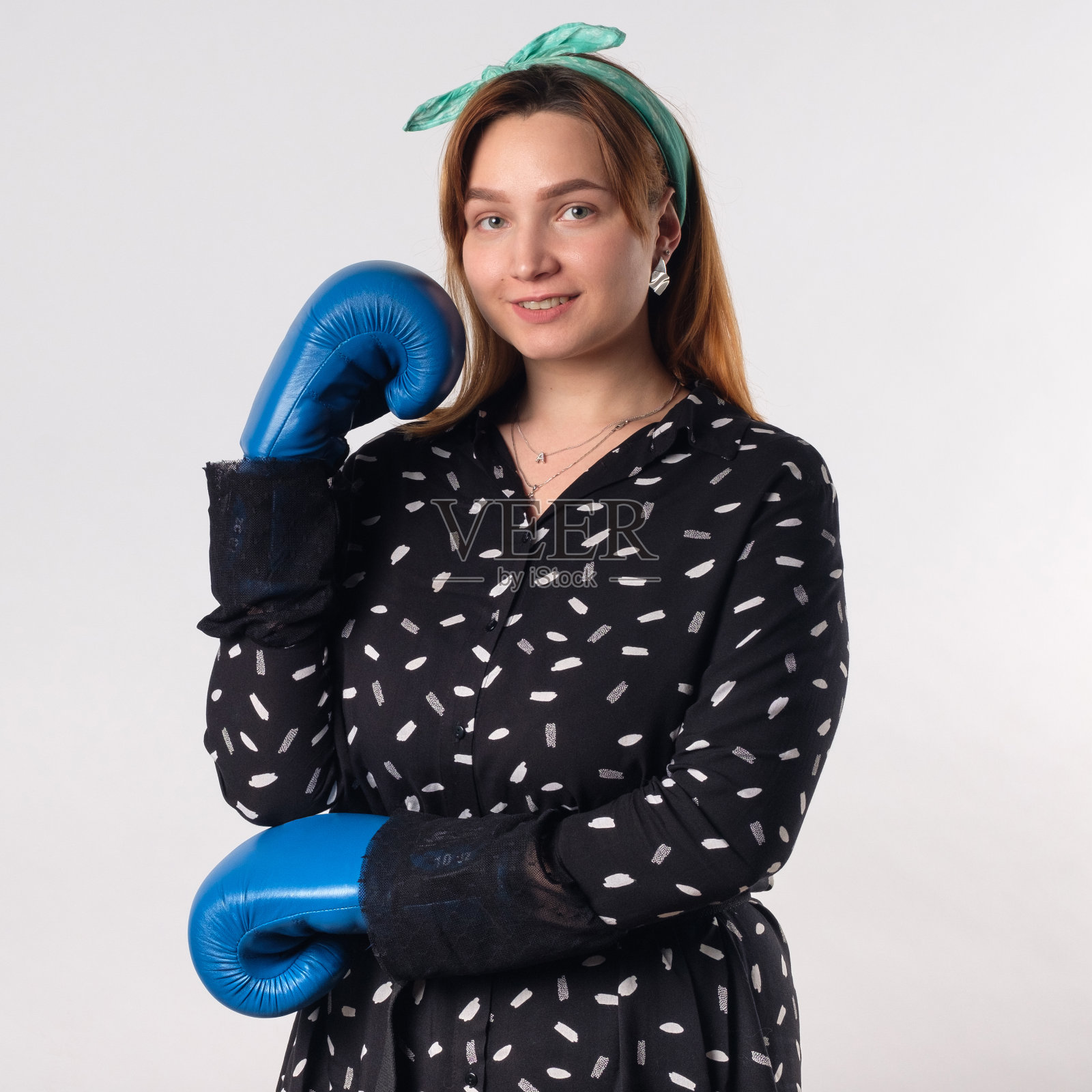 女孩力量的概念。自信的年轻女子孤立在灰色的墙壁背景。女性和独立的力量。照片摄影图片