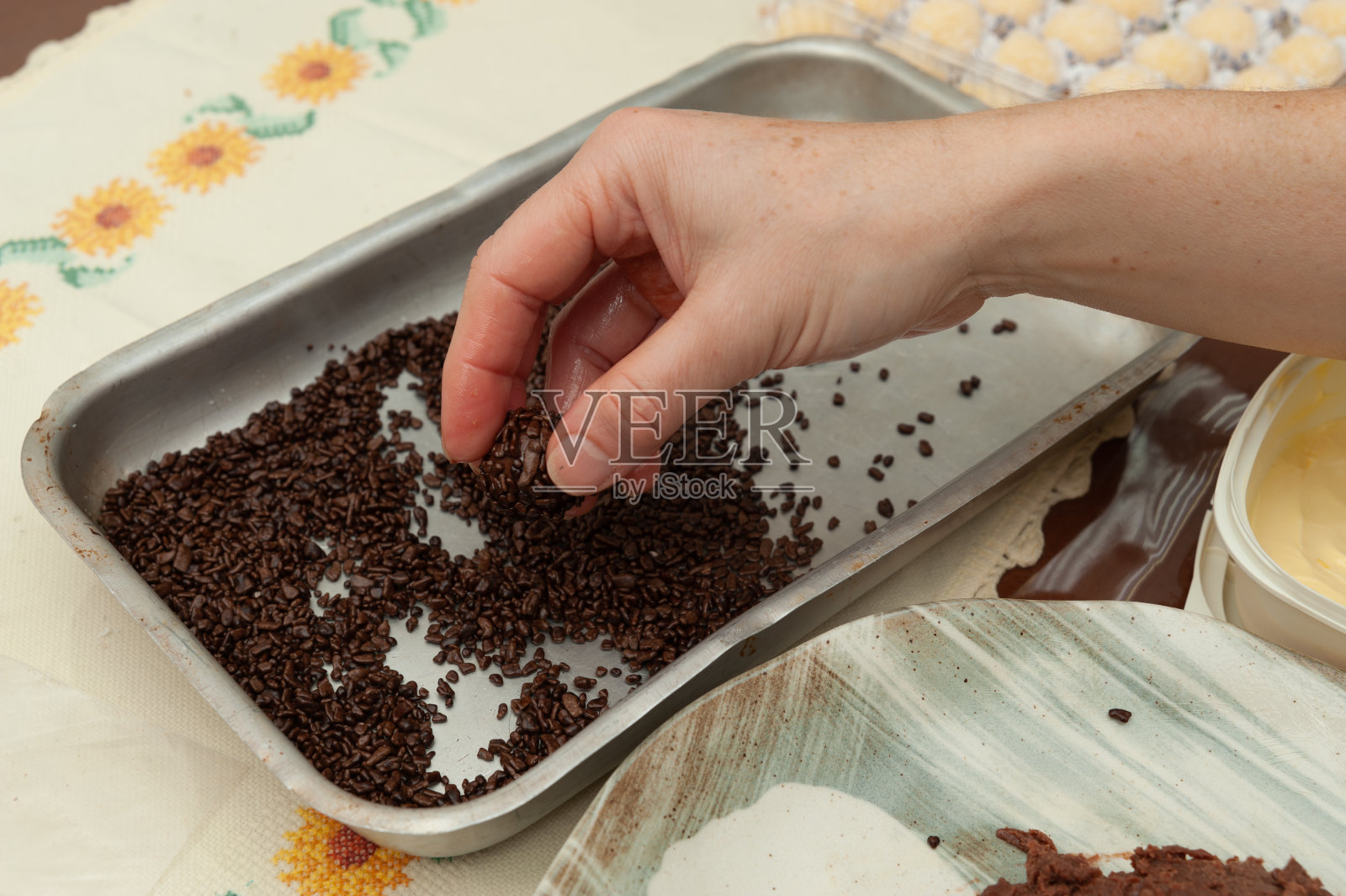 女人的手制作美味和传统的“u201cBrigadeiros”u201d(巴西软糖球)在铝托盘上的特写。侧视图。照片摄影图片