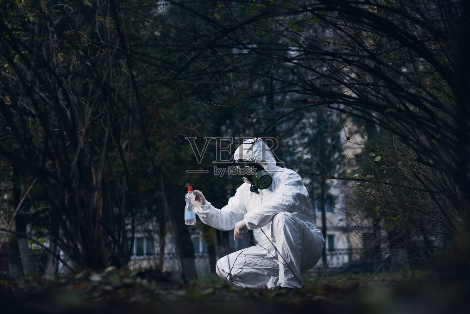 科学家在户外做研究，穿着白色工作服和防毒面具照片摄影图片