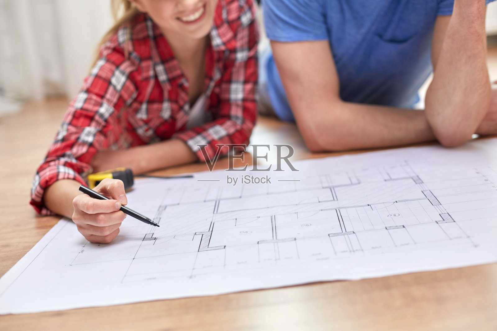 微笑的夫妇在家里看蓝图照片摄影图片