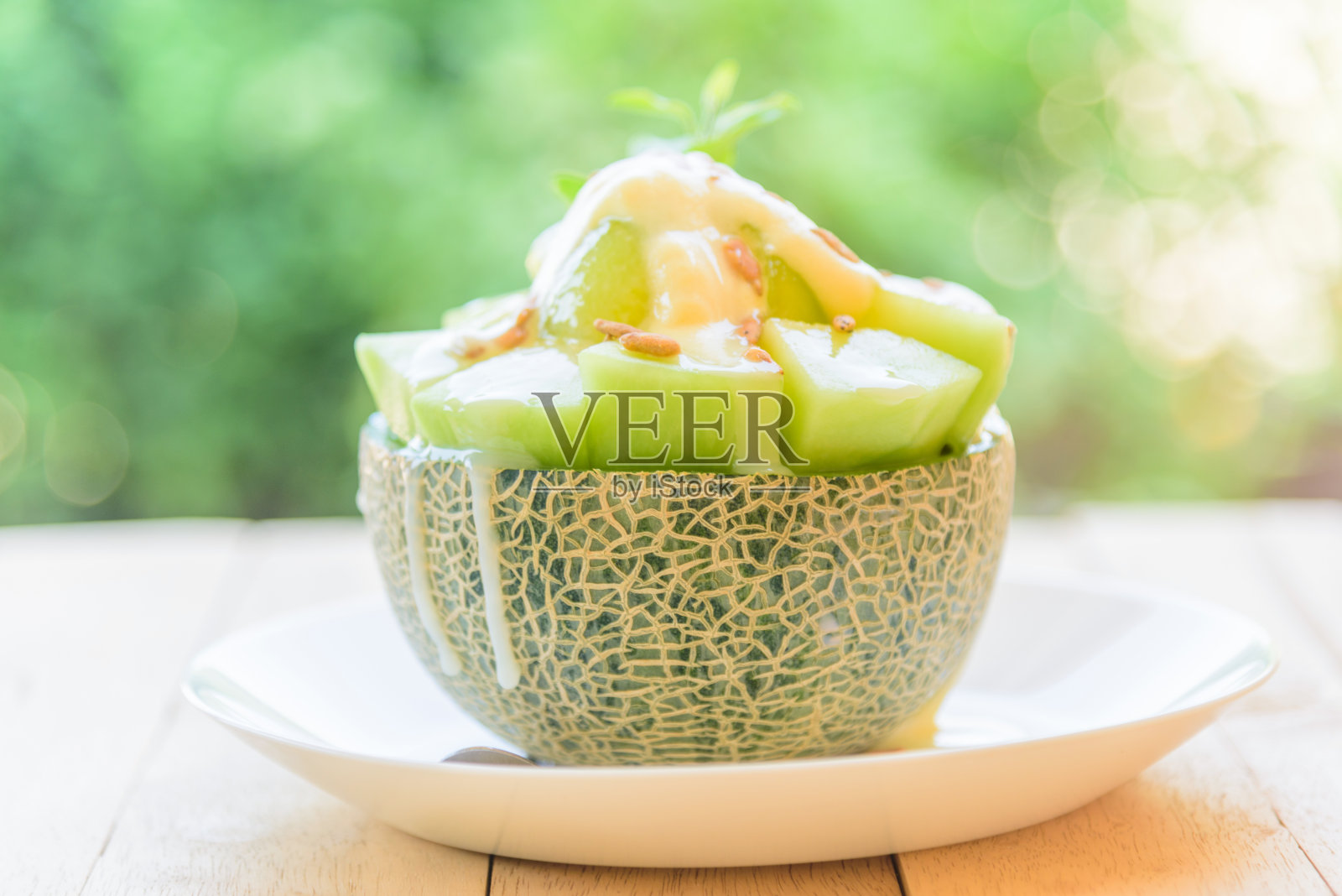 蜜瓜冰酥配甜炼乳放在木桌上照片摄影图片