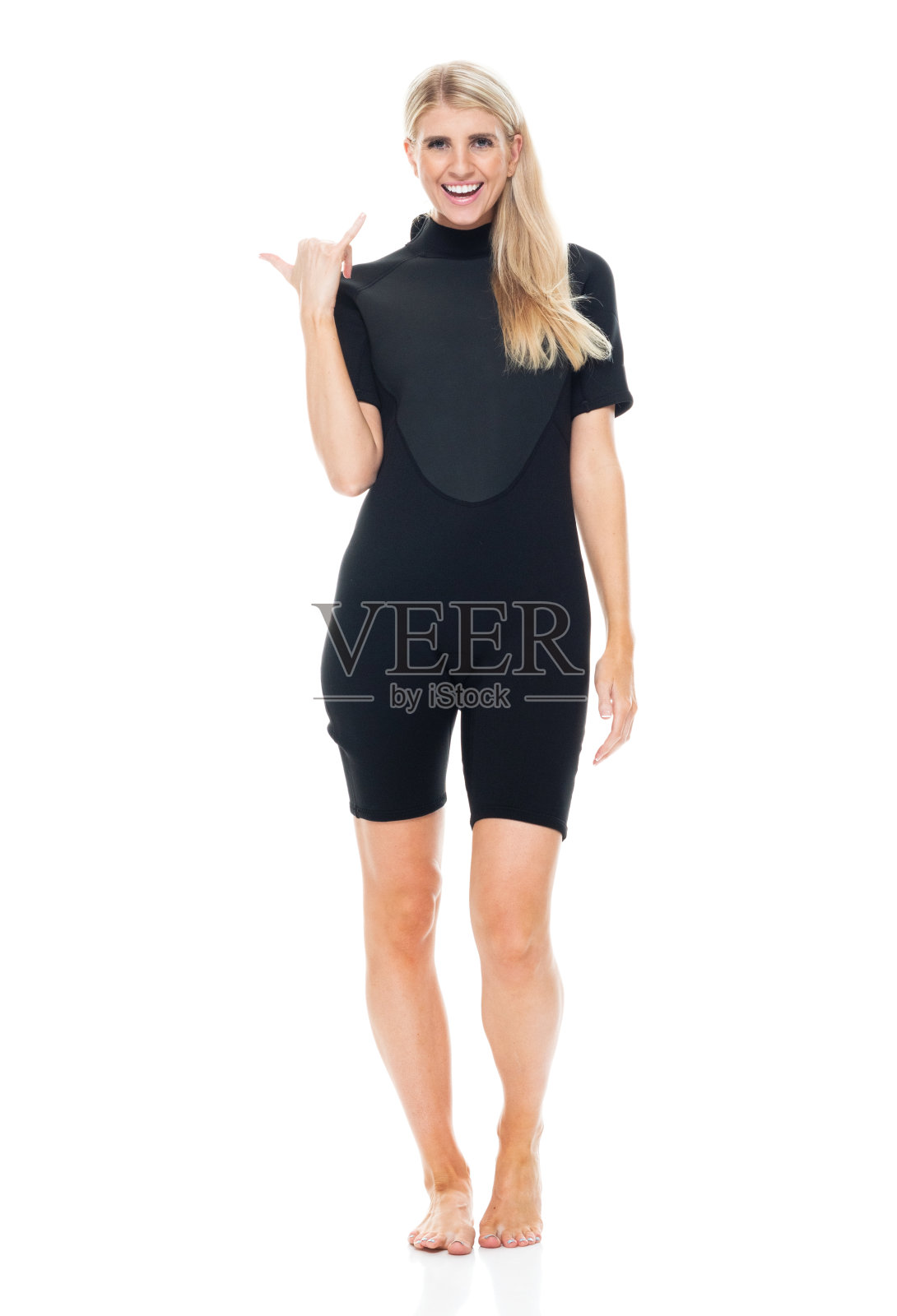 白人年轻女性穿着潜水服站在白色背景前照片摄影图片