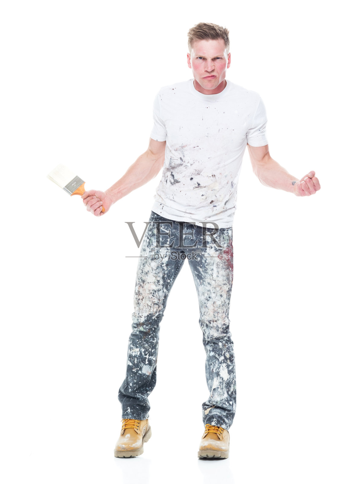 白人男性画家站在白色背景穿着牛仔裤和拿着画笔照片摄影图片