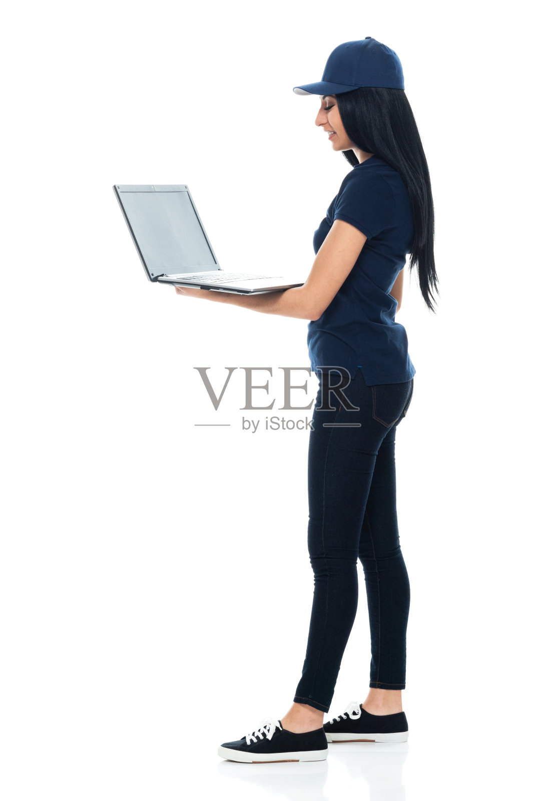 拉丁美洲和西班牙裔女性体力劳动者站在前面的白色背景戴着棒球帽和使用电脑照片摄影图片